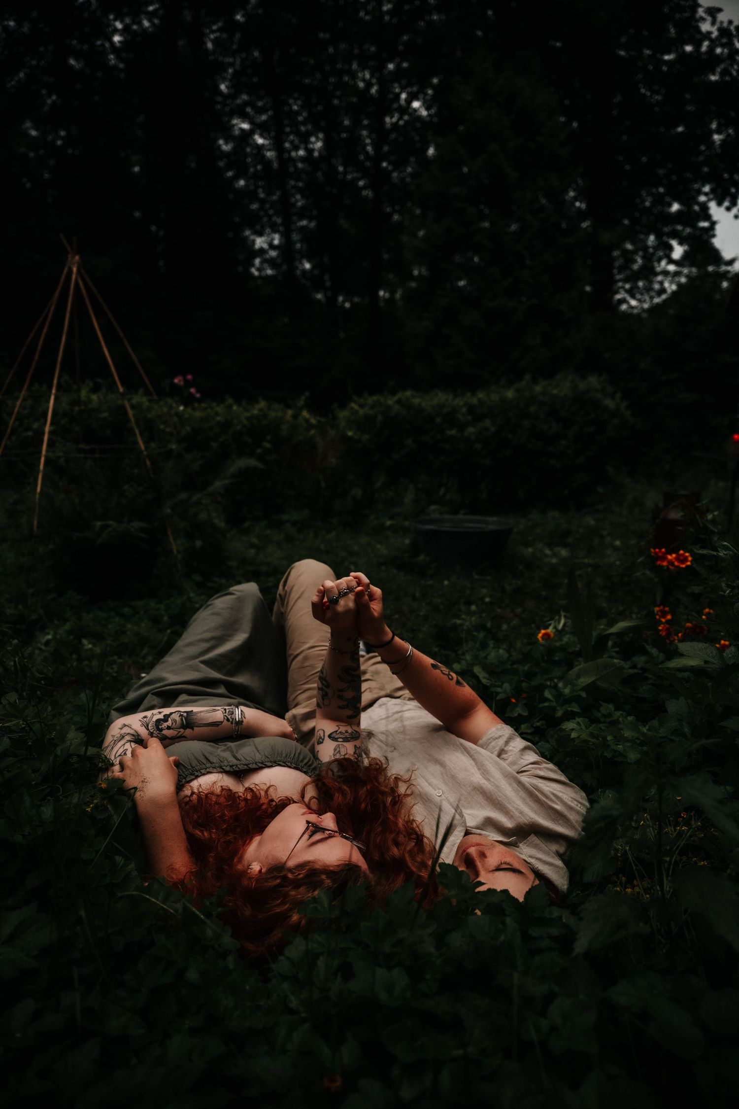 Artistic sequence of figure laying on grass amid dark moody forest setting with dramatic lighting and composition.