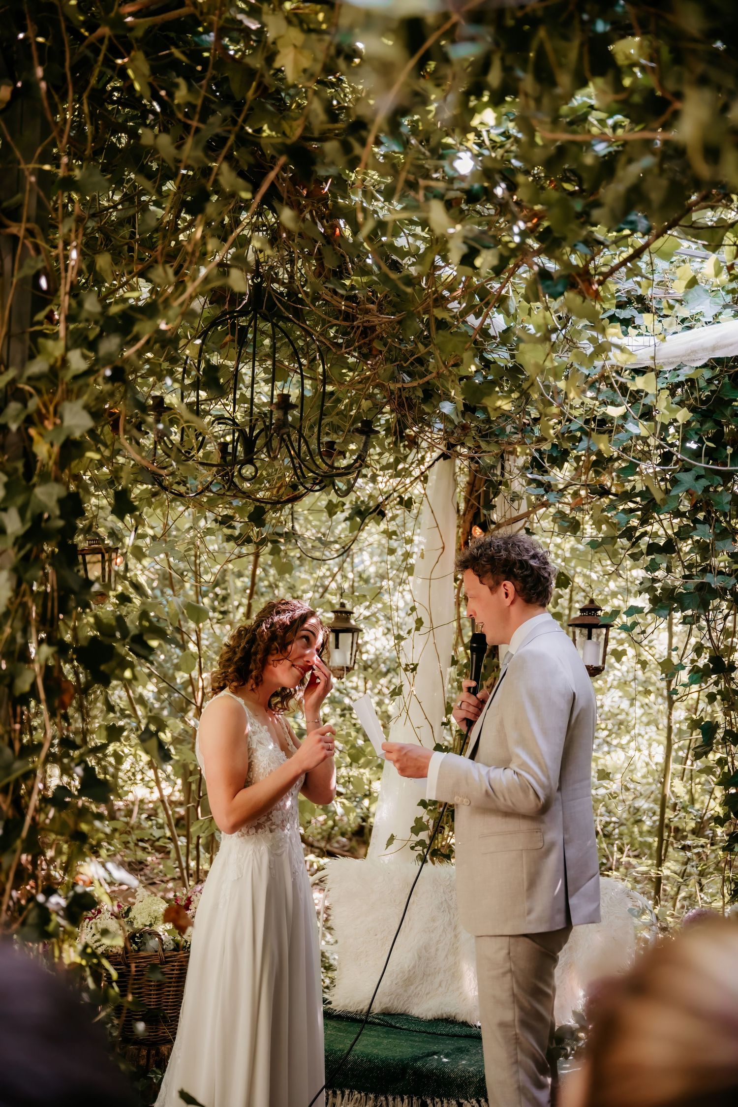 Wedding celebration in a leafy garden setting with natural light filtering through.