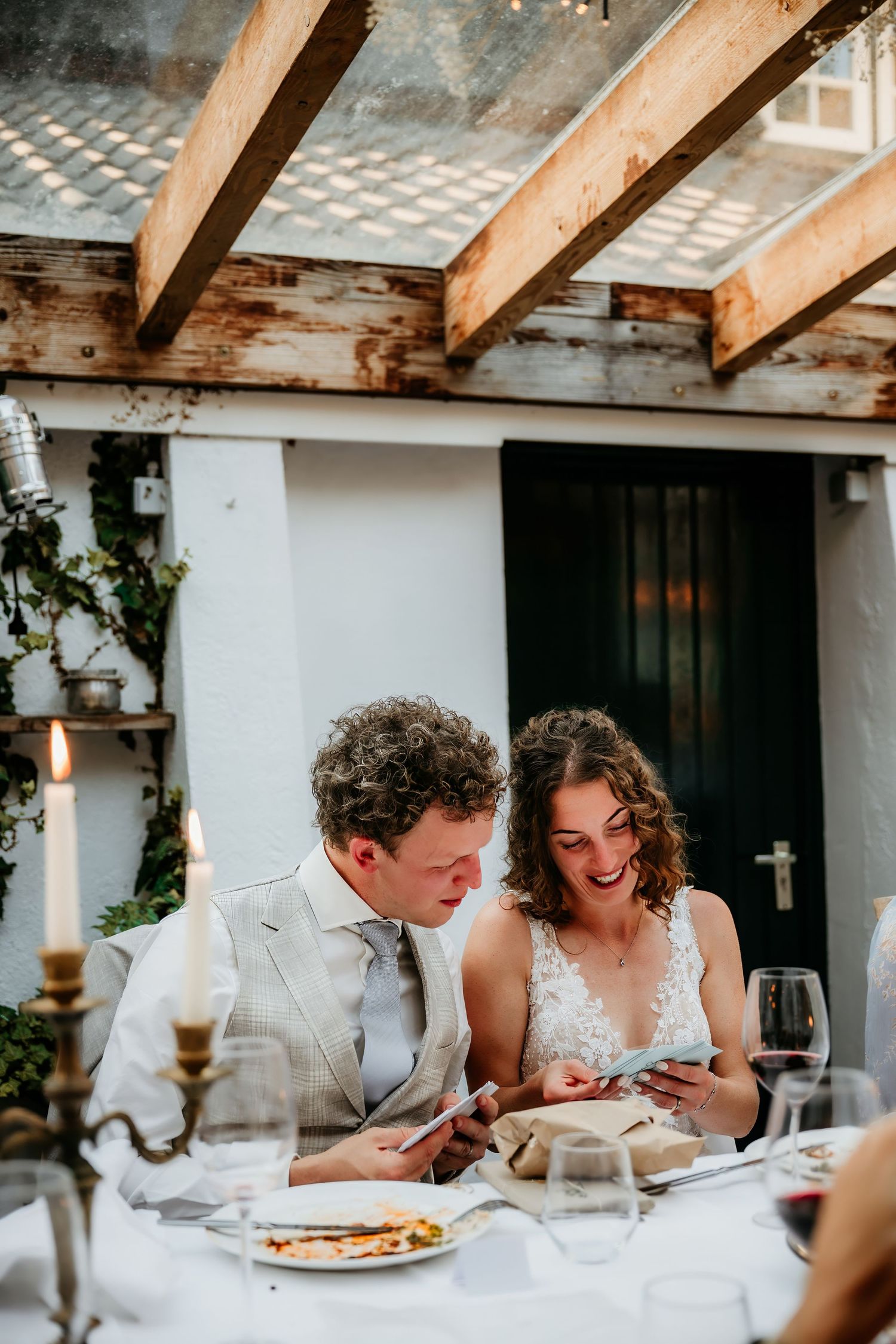 Intimate dining moment at rustic wedding reception under wooden beamed ceiling.
