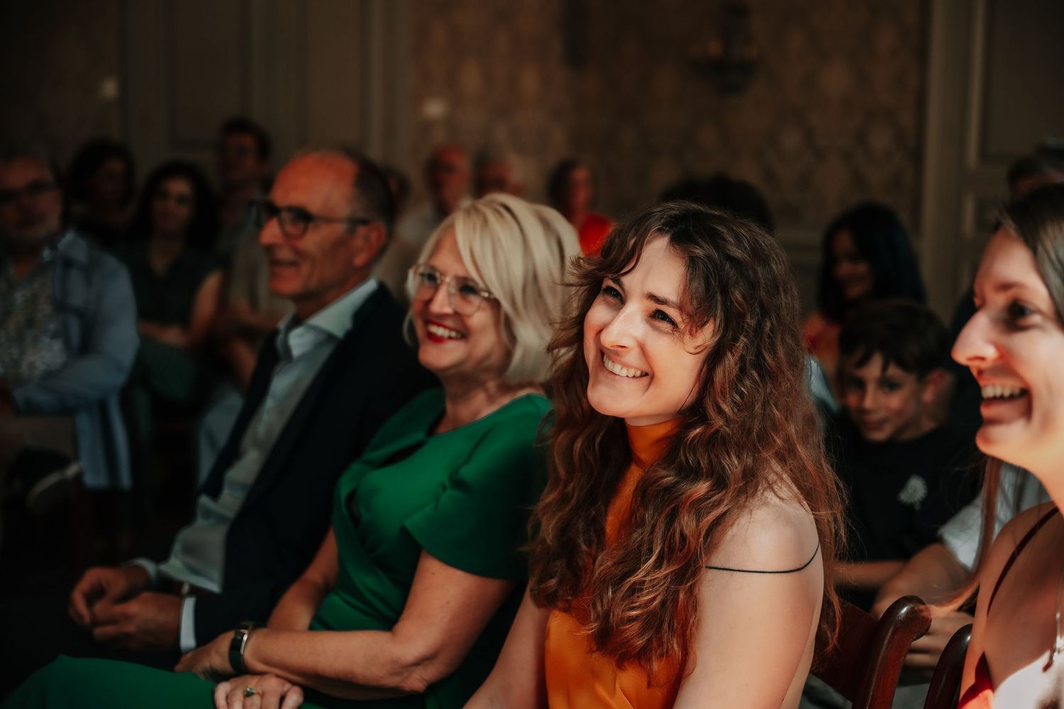 Wedding reception guests enjoying entertainment in warm lighting.