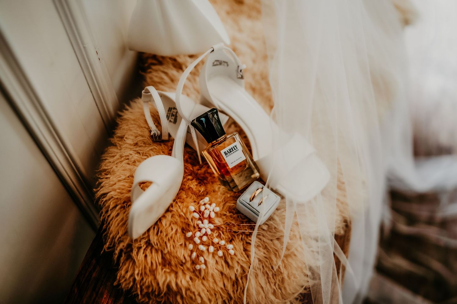 Close-up view of a teddy bear wearing a white bow tie and holding a small glass bottle.