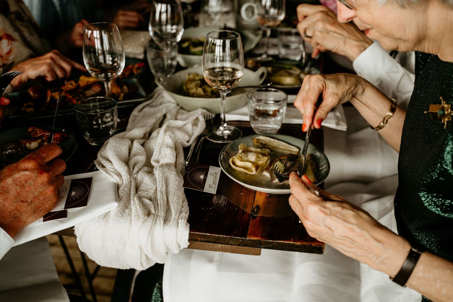 Guests dining at a formal event with wine glasses and table settings.