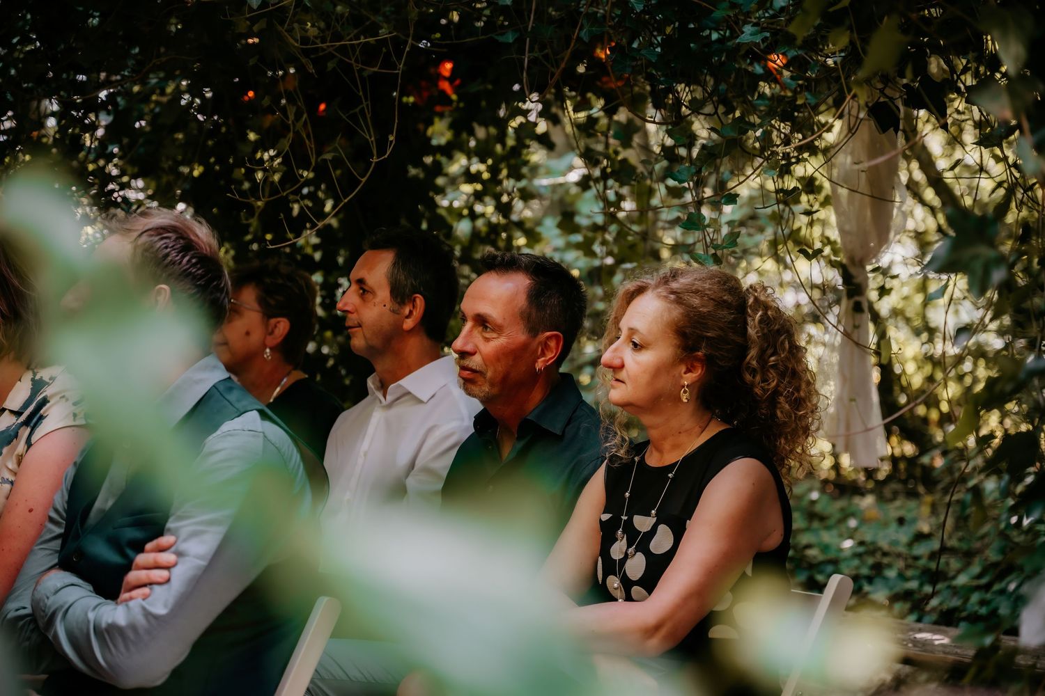 Wedding celebration in lush garden setting with natural greenery backdrop.