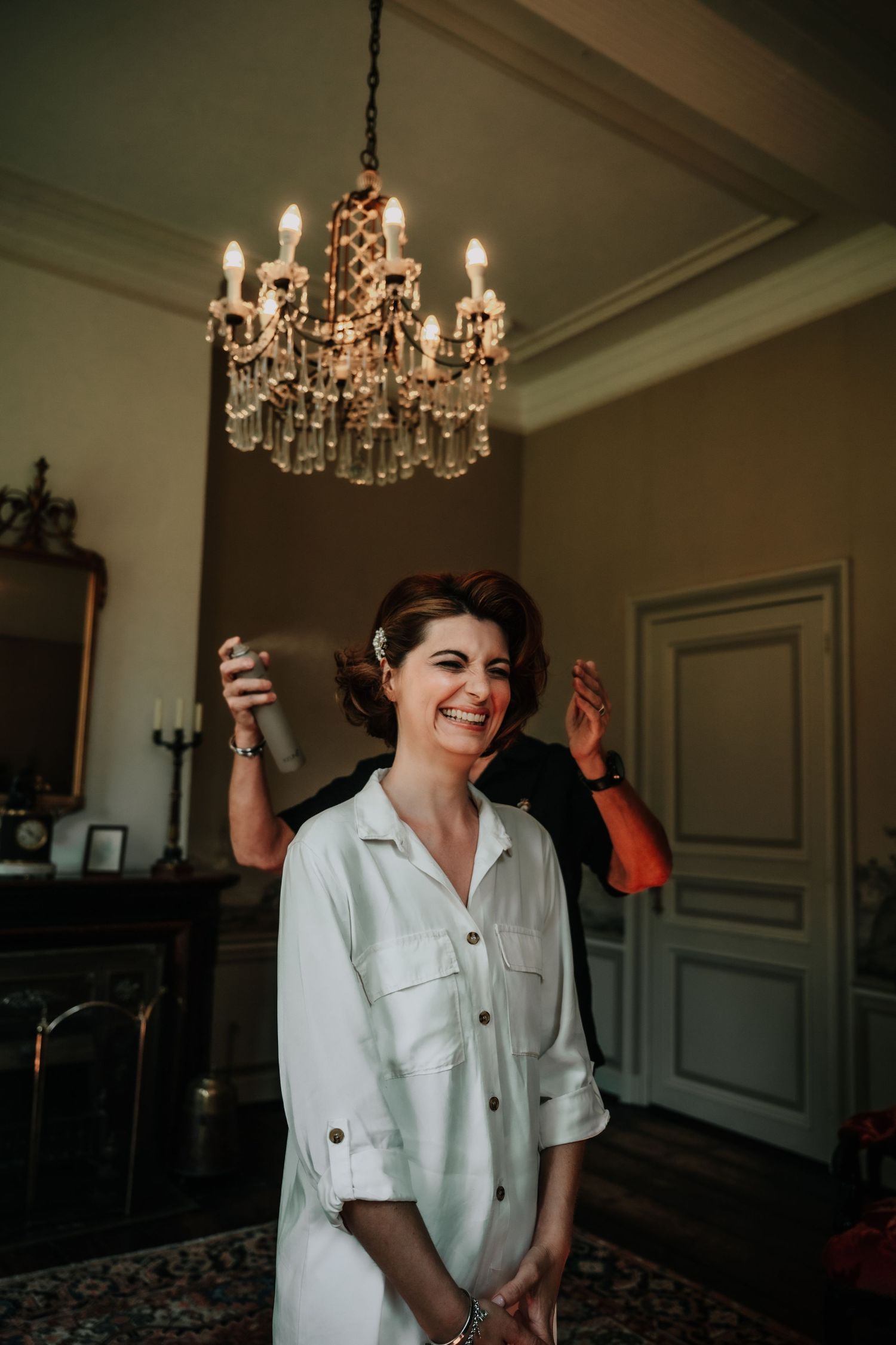 Dancing with joy in an elegant room with crystal chandeliers overhead.