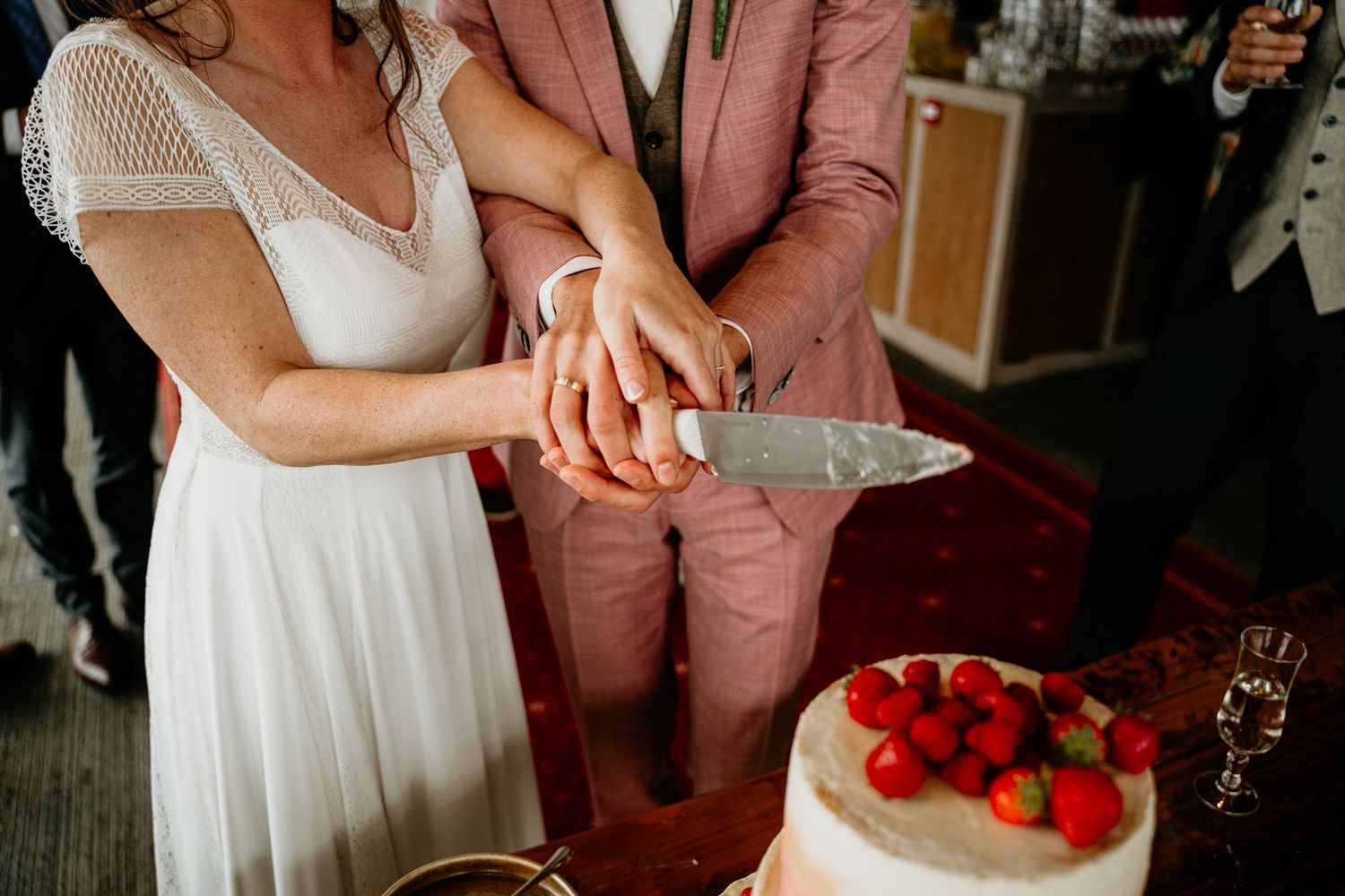 Wedding reception details with cake cutting and champagne glasses.