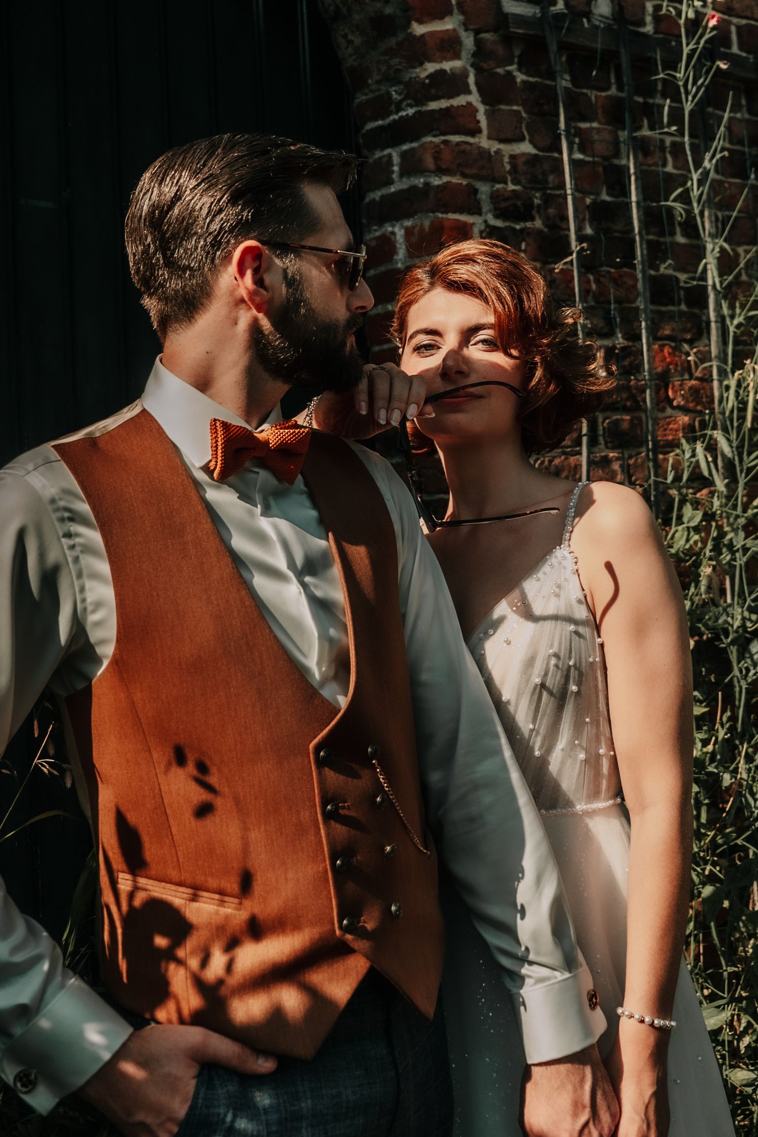 Sun-dappled portraits against a brick wall creating dramatic light and shadow patterns.