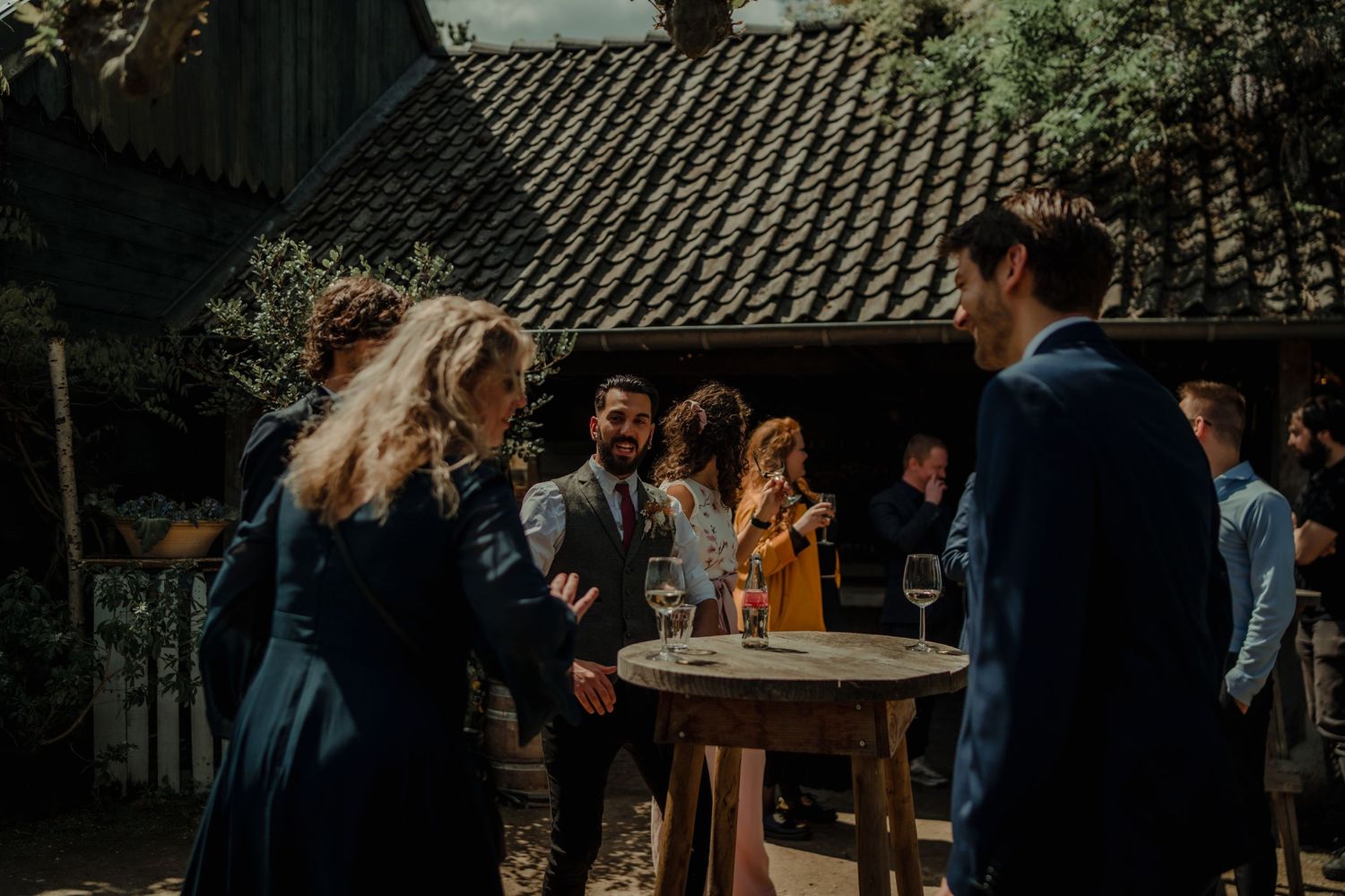 Wedding guests mingling during an outdoor cocktail reception under string lights.