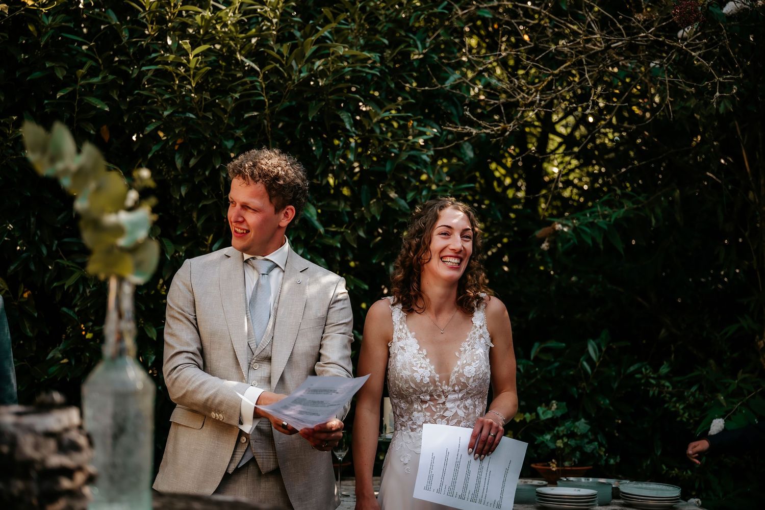 Joyful outdoor wedding celebration with guests in formal attire.