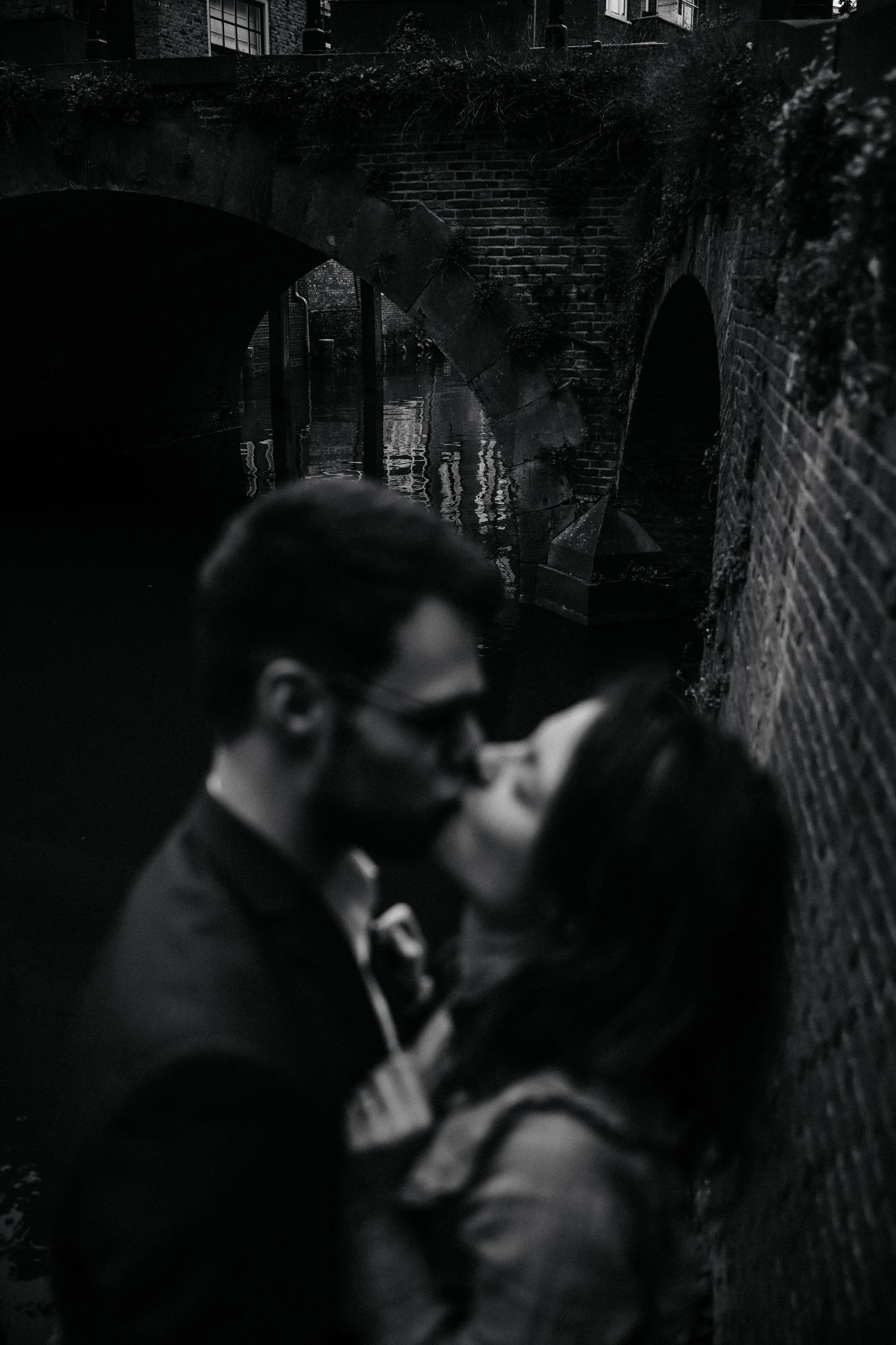 A cinematic sequence of silhouettes in shadow embrace in black and white dramatic lighting.