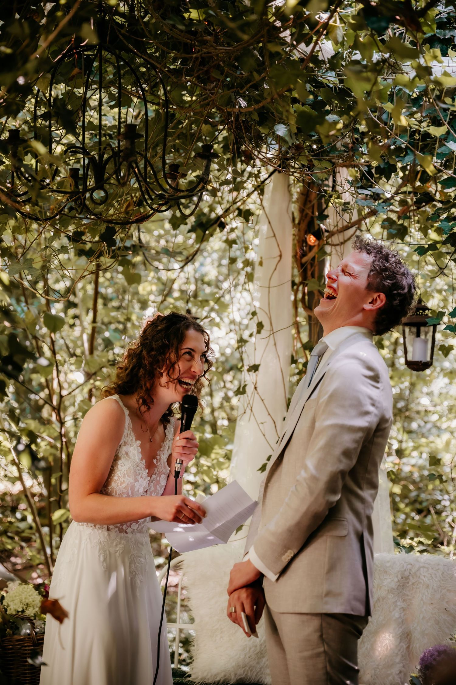 A romantic moment captured in a garden setting with dappled sunlight filtering through the trees.