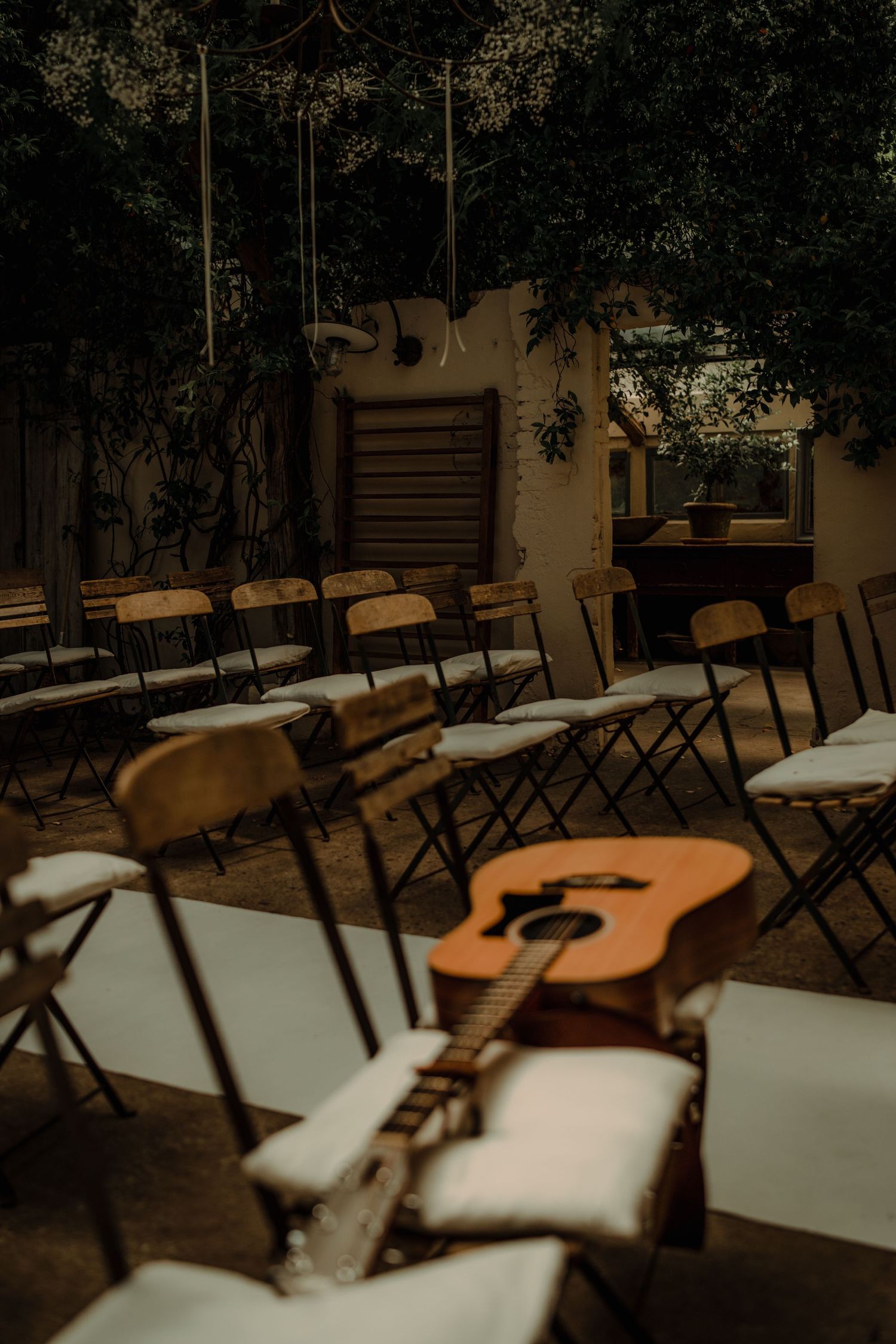 Rows of folding chairs and an acoustic guitar set up for an outdoor ceremony.