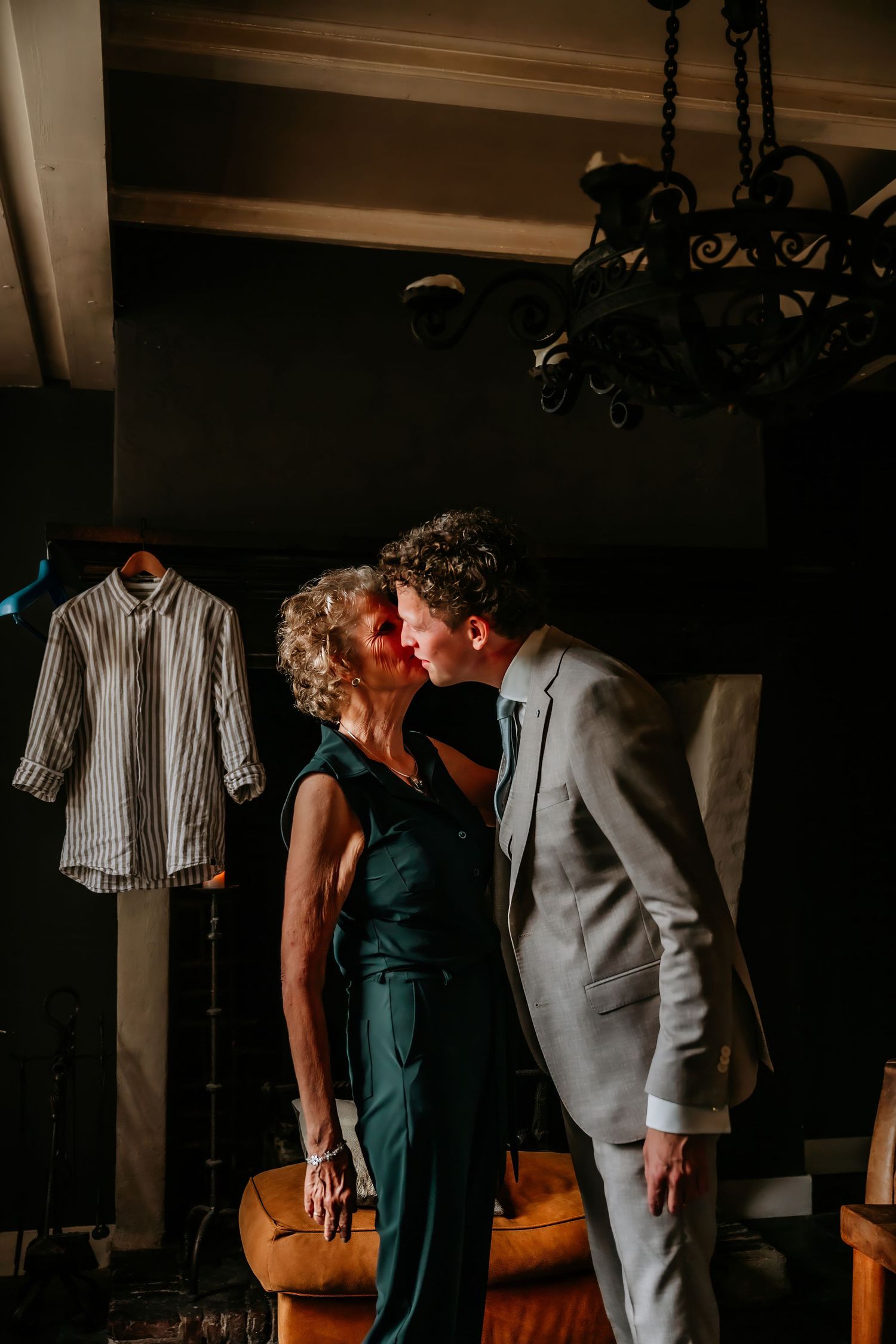 An intimate moment captured in a dark room with emerald green walls and vintage decor.