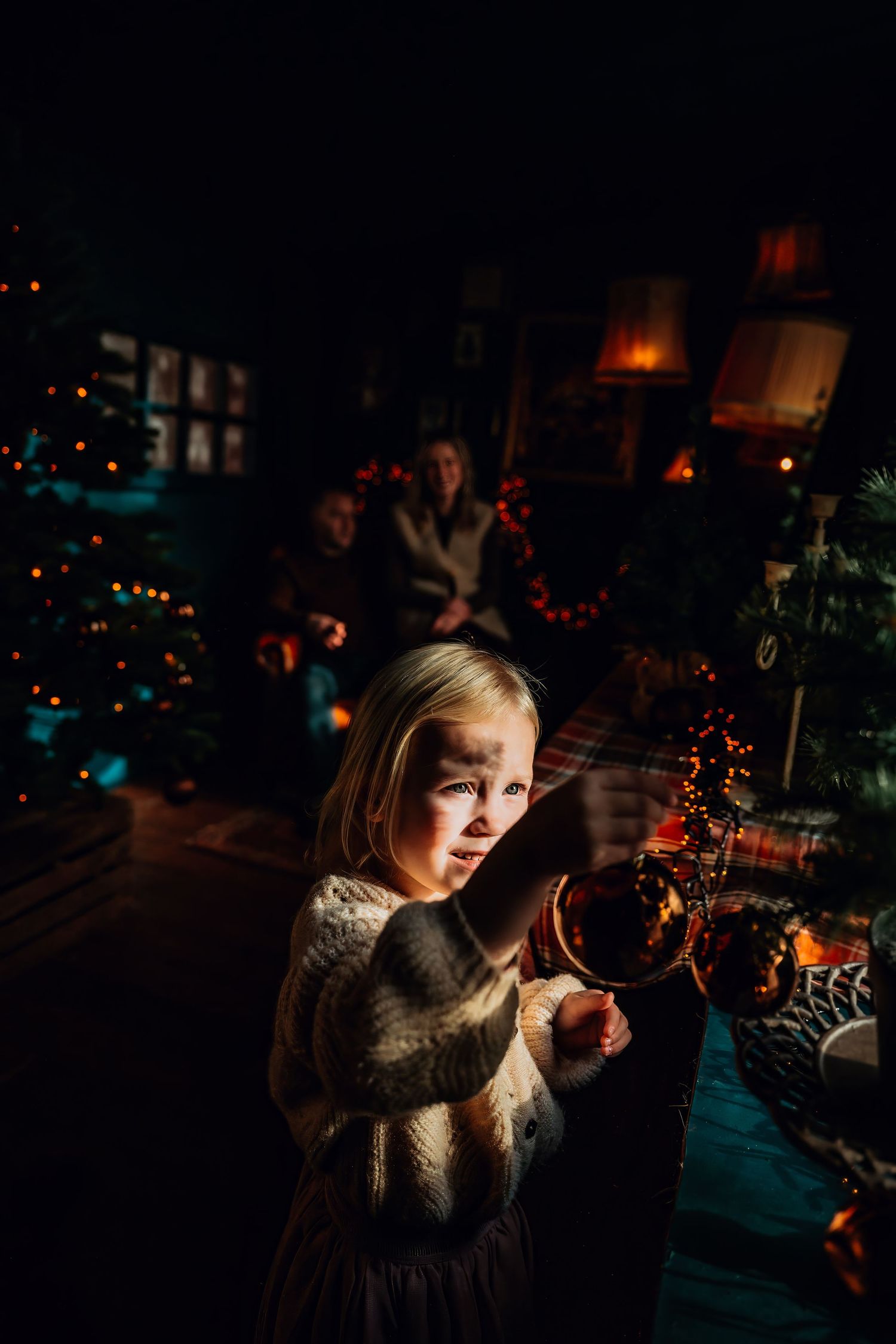 Person in dim lighting takes photos with a camera at a nighttime event.