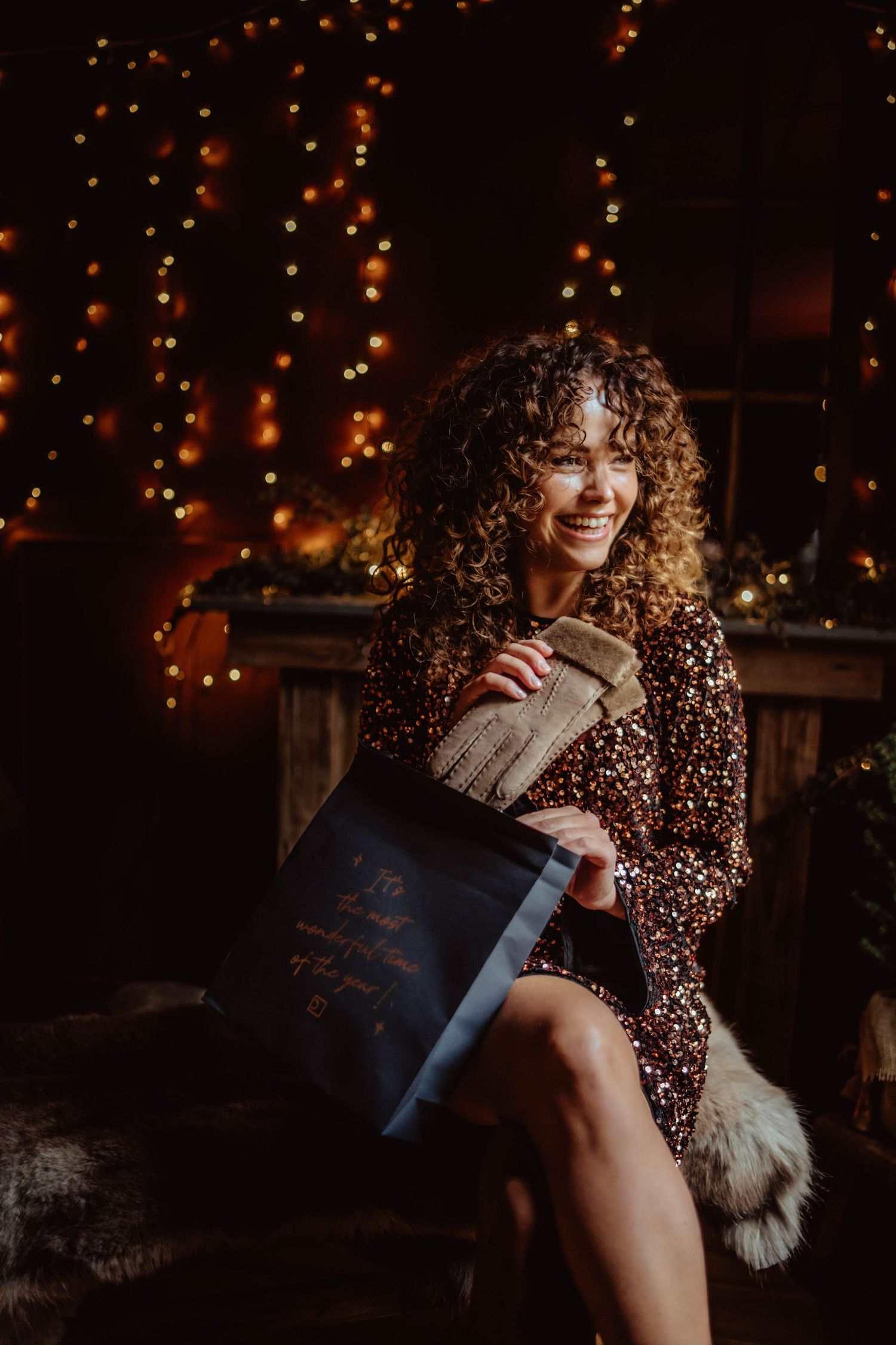 A cozy winter photoshoot with glowing string lights and warm sweaters creating an intimate holiday atmosphere.