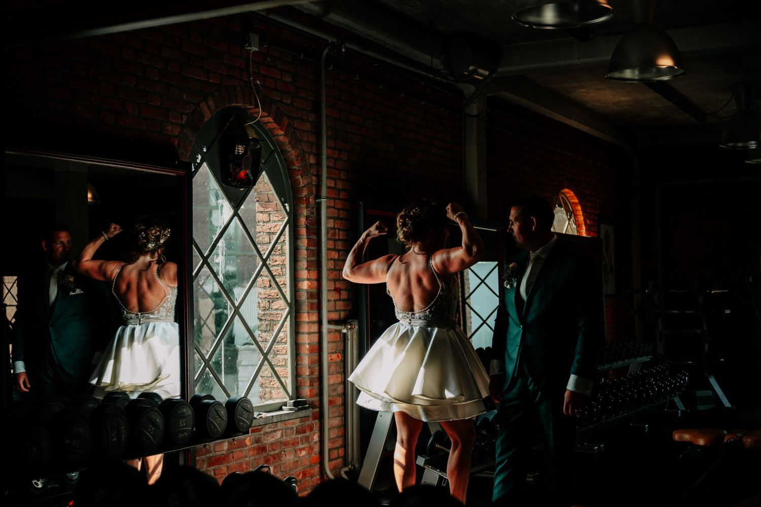 Couples dancing on a wooden floor in a dimly lit venue with brick walls and diamond-paned windows.