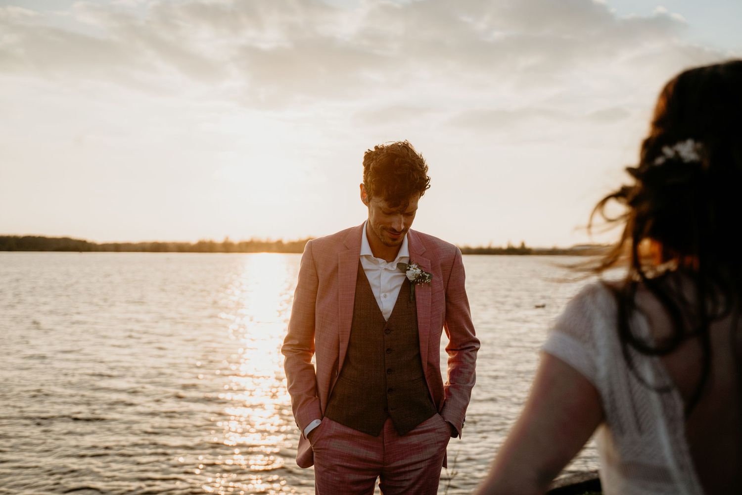 Romantic sunset beach wedding photos with golden light reflecting off the water.