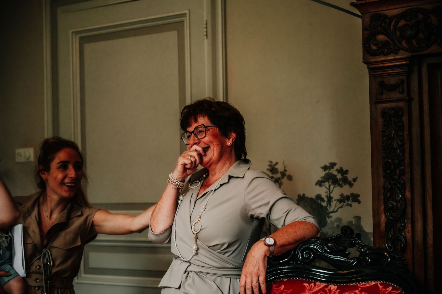 Candid moment of laughter and joy at an indoor gathering with warm lighting.