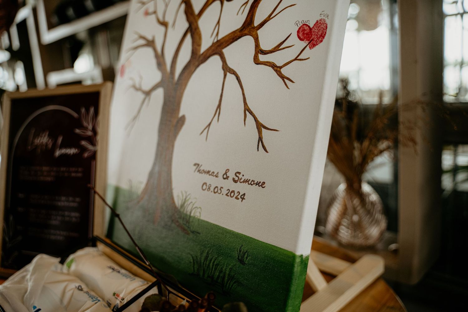 Wedding decorations featuring delicate tree branch designs with red heart accents.