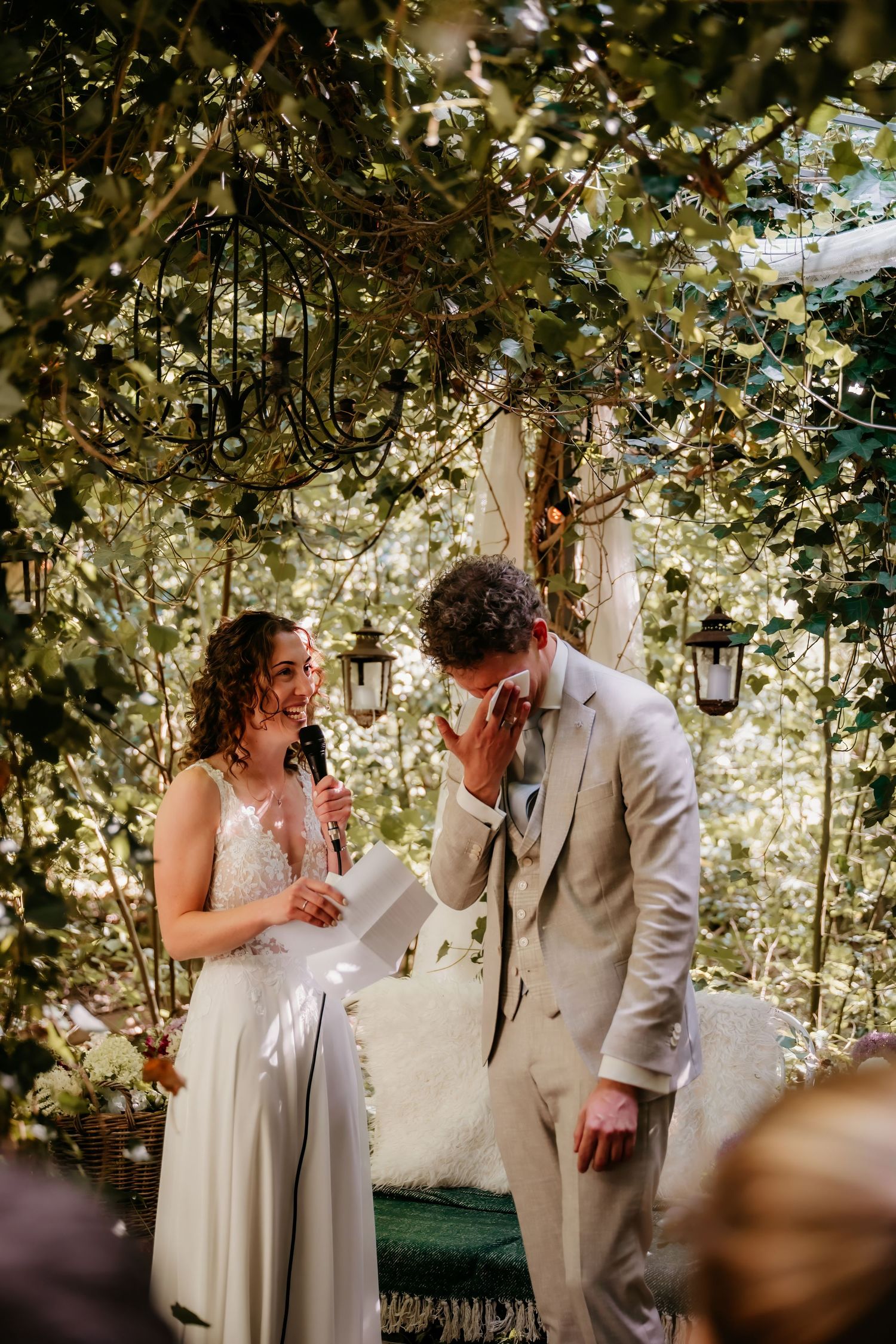 A romantic garden wedding ceremony under a canopy of twinkling lights and greenery.