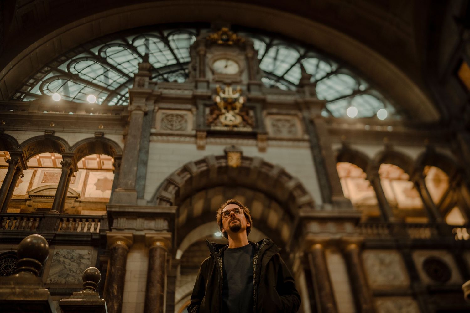 Ornate interior of a grand historic train station with vaulted glass ceilings and classical architectural details.