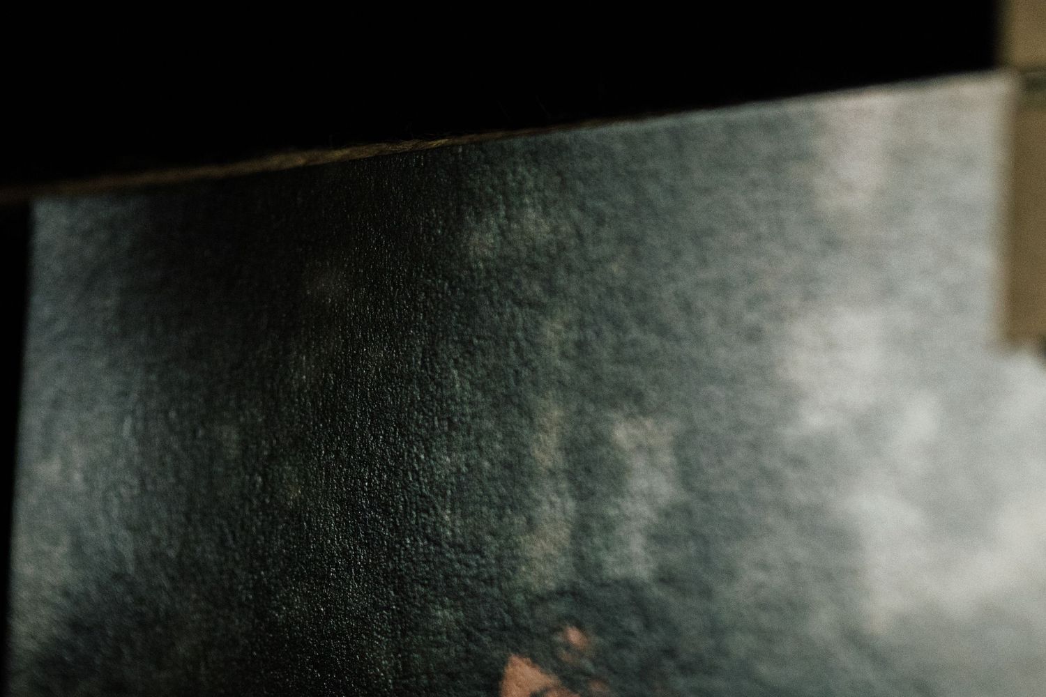 Close-up of a dark, textured surface with subtle light reflections and worn details.