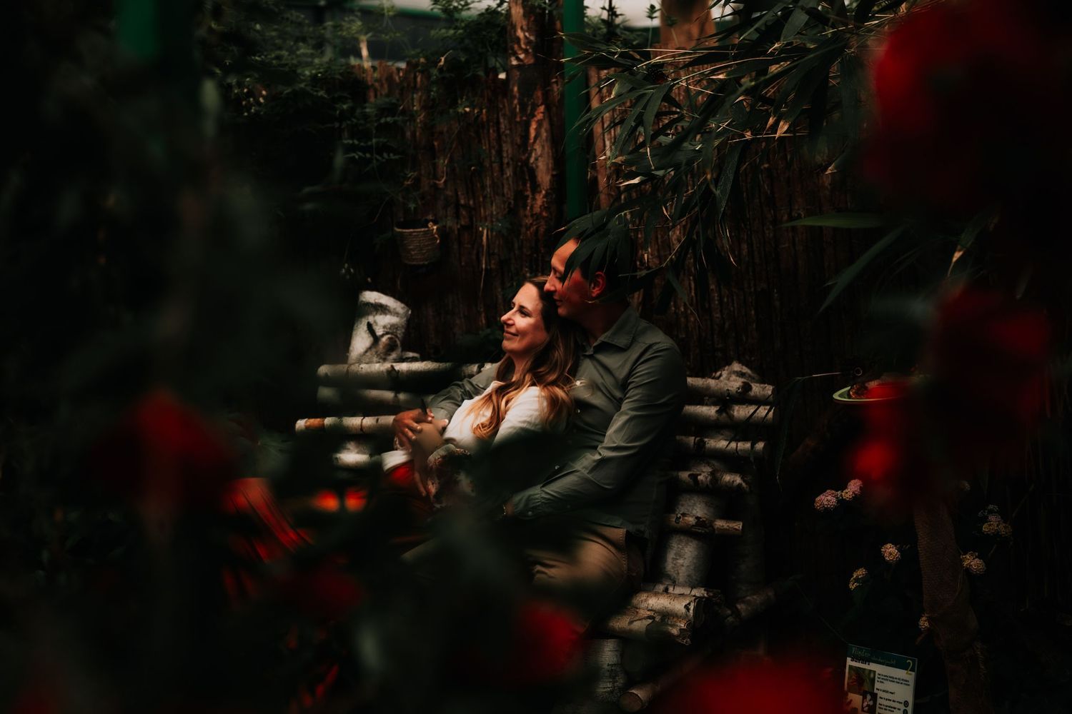 A romantic vintage wedding scene with a couple dancing in a dimly lit venue with red decorative lighting.