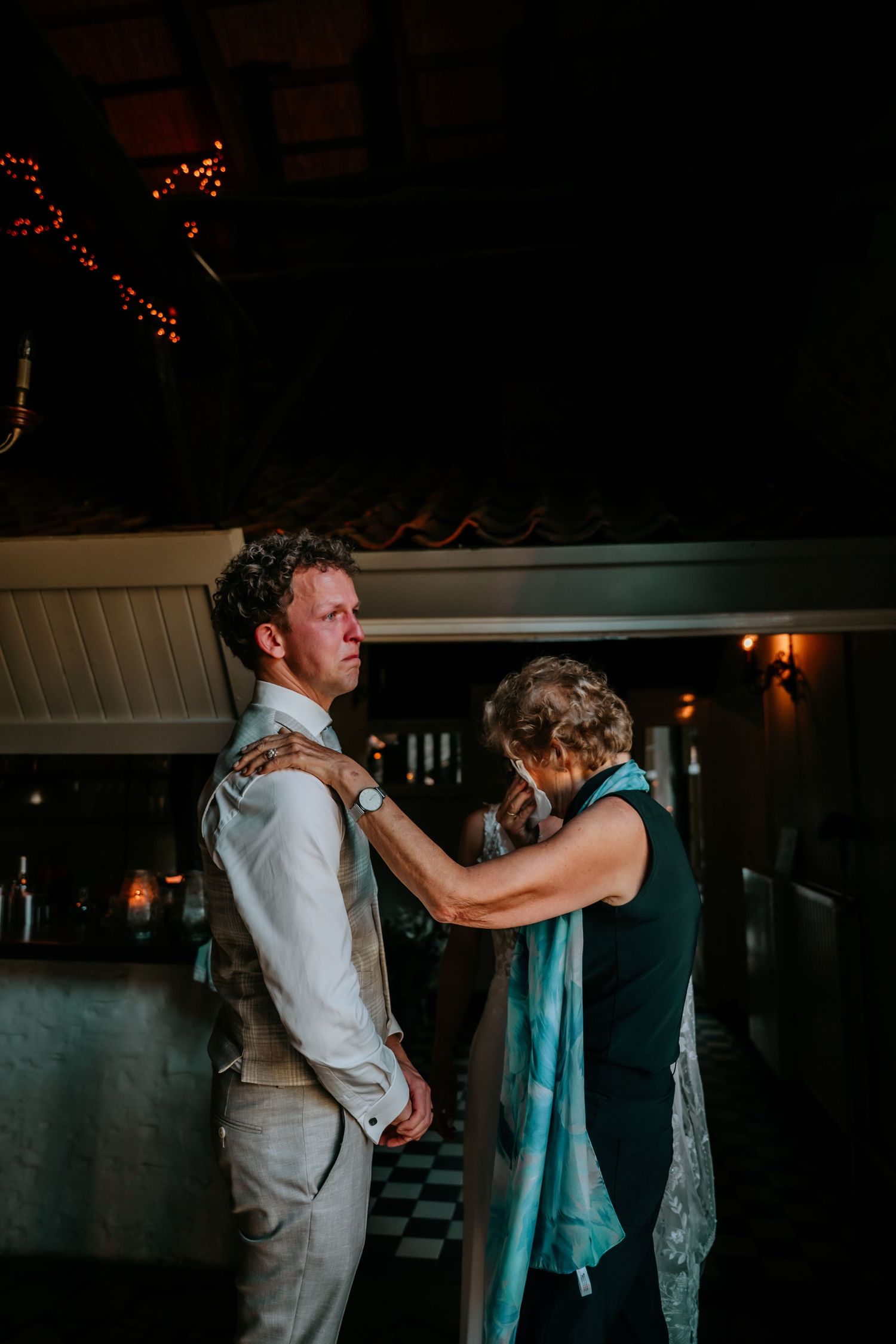 Couple dancing together in a dimly lit venue with romantic lighting.