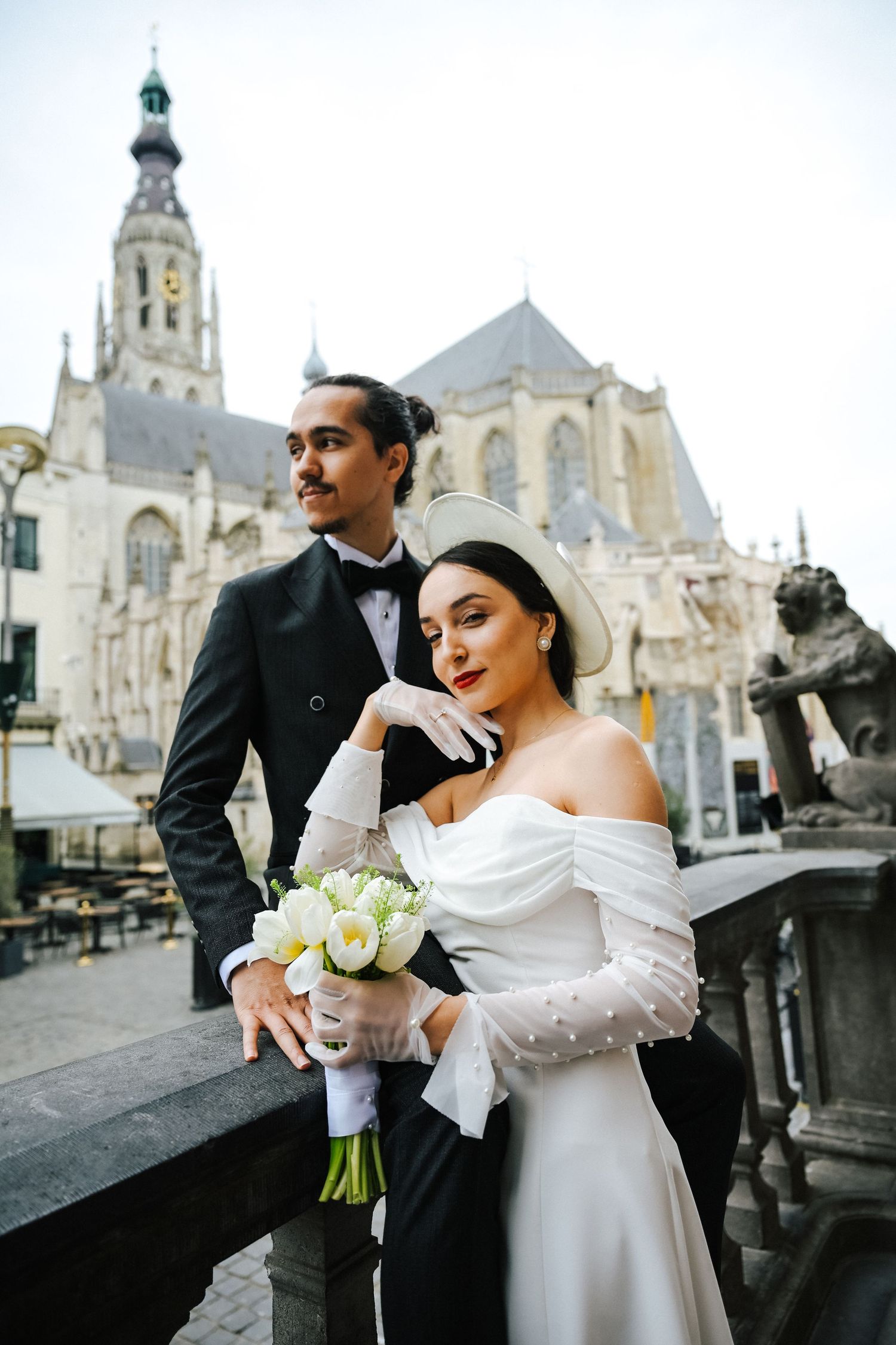 A romantic wedding photo shoot on the steps of a grand European church with gothic architecture in the background.