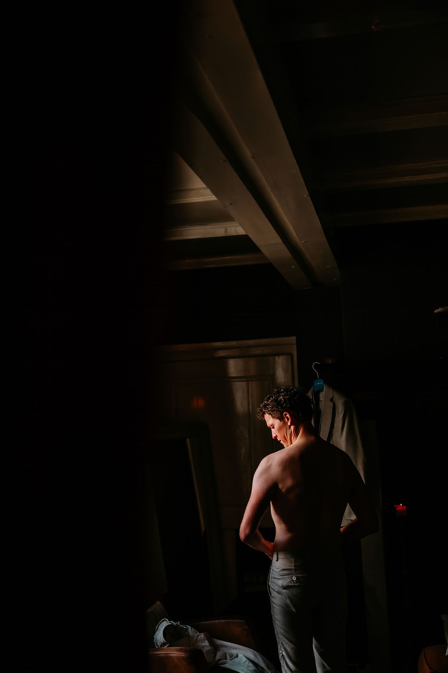 Silhouetted figures getting ready in a dimly lit room with dramatic lighting and shadows.