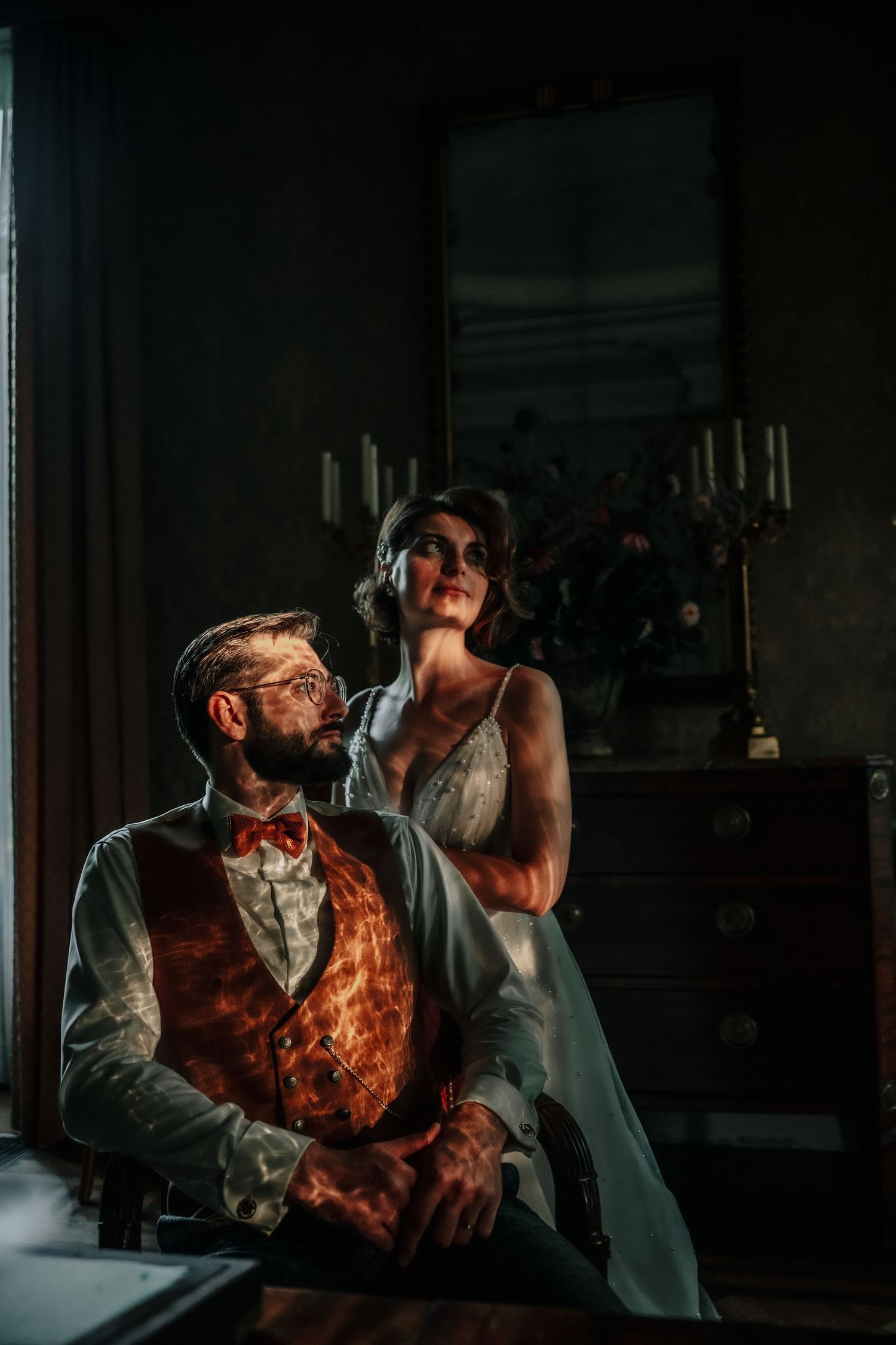 A figure in vintage attire sits in moody lighting drinking from a bottle across a series of dramatic shots.