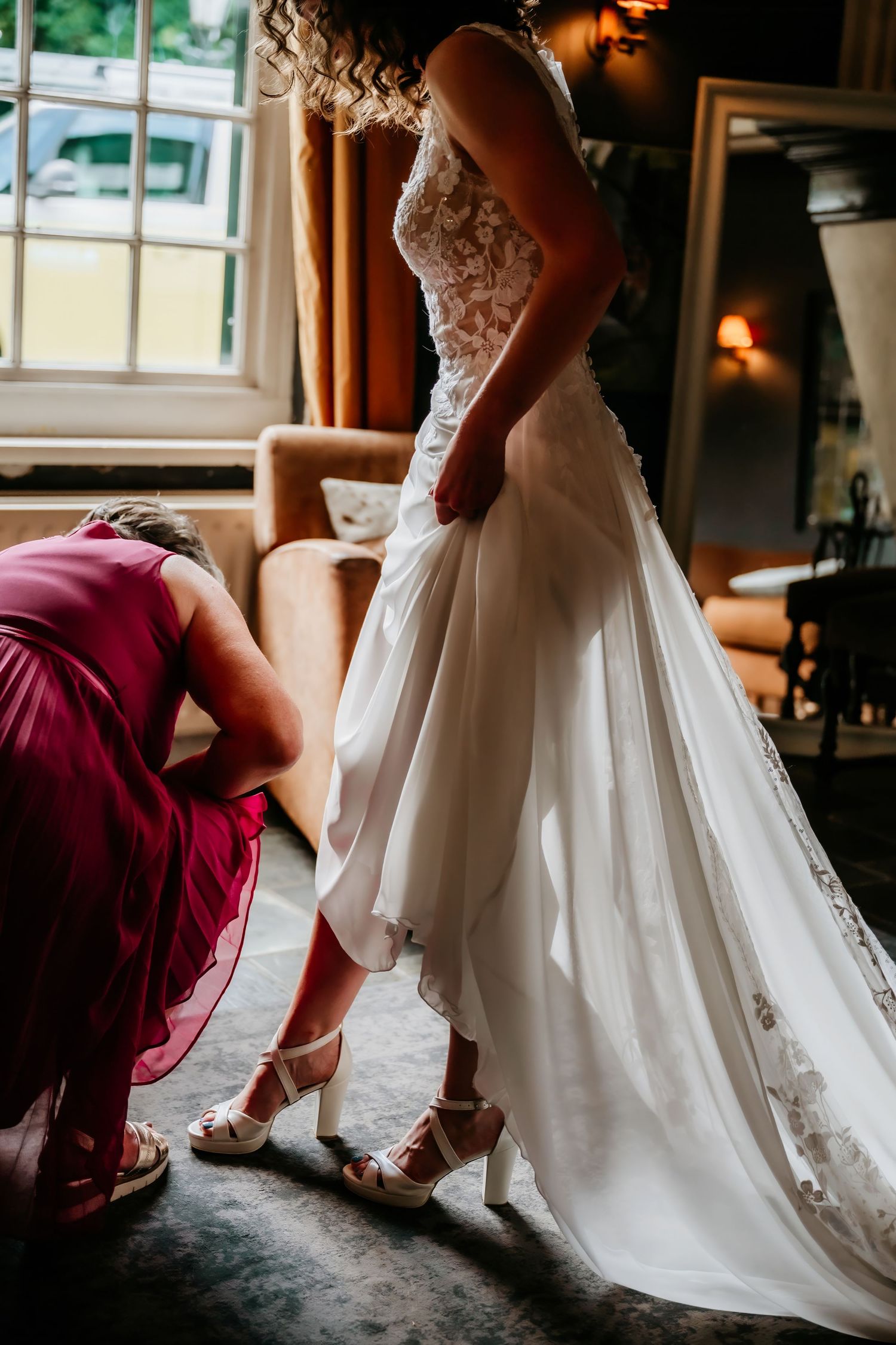 Close-up of wedding dress details and shoes being put on during bridal preparation.
