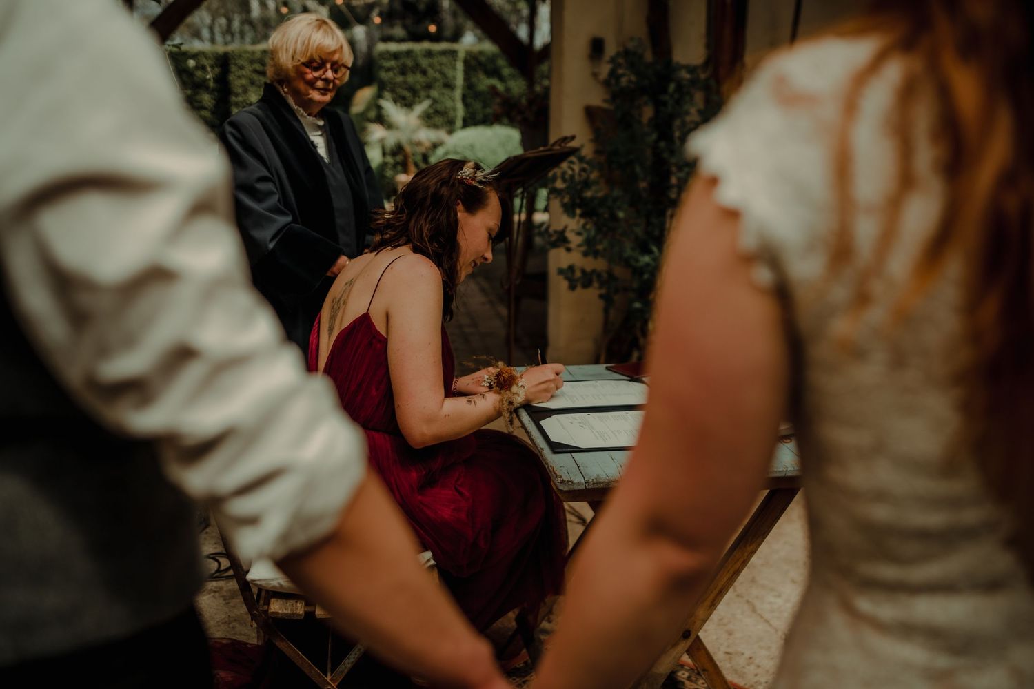 Wedding ceremony document signing in an intimate garden setting.