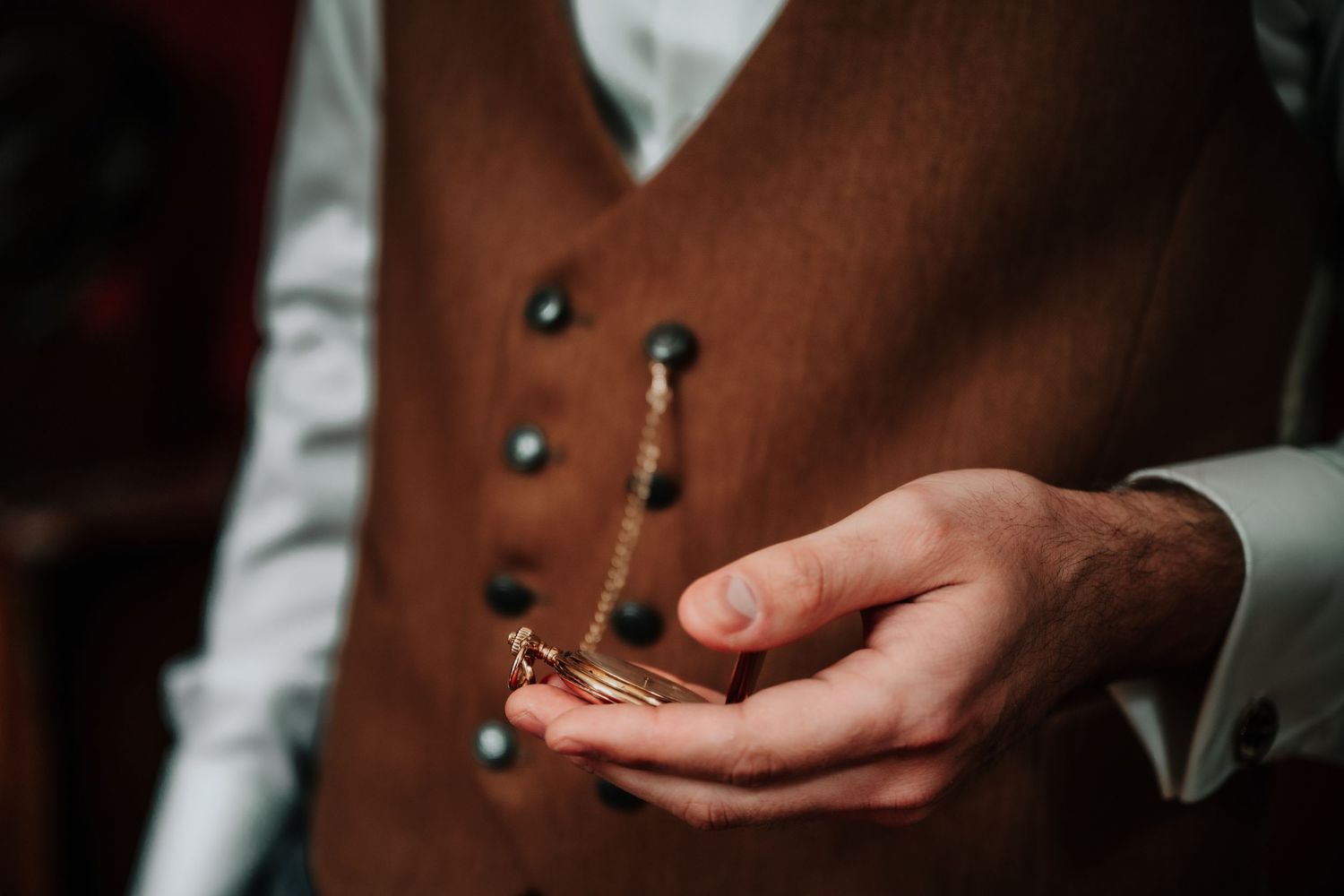 Close-up shot of hands holding a wedding ring in natural lighting.