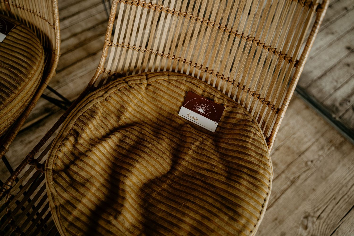 A brown leather wallet sits on a rattan chair casting dramatic shadows across the surface.