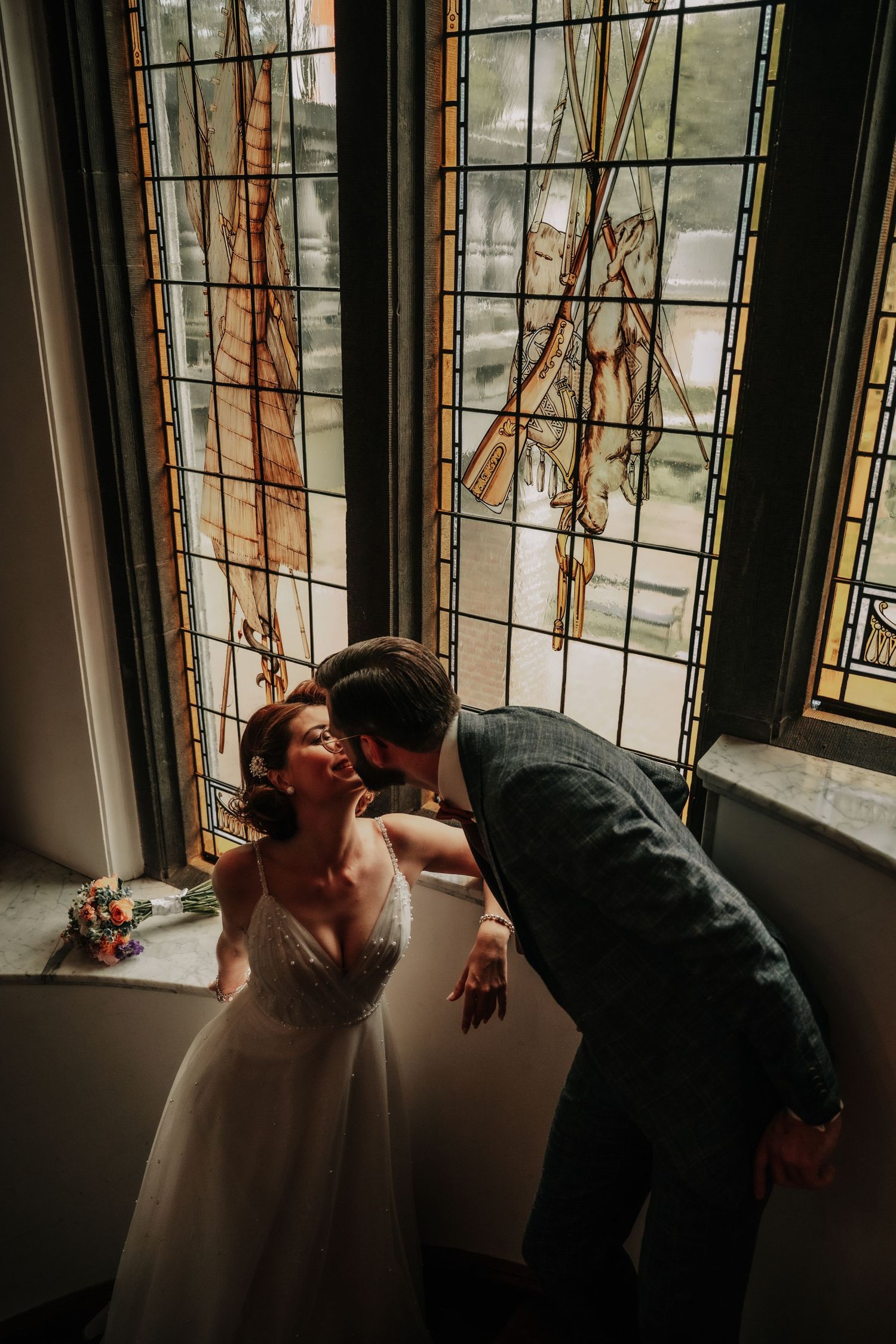 A sequence showing someone looking out through a decorative stained glass window in dramatic lighting.