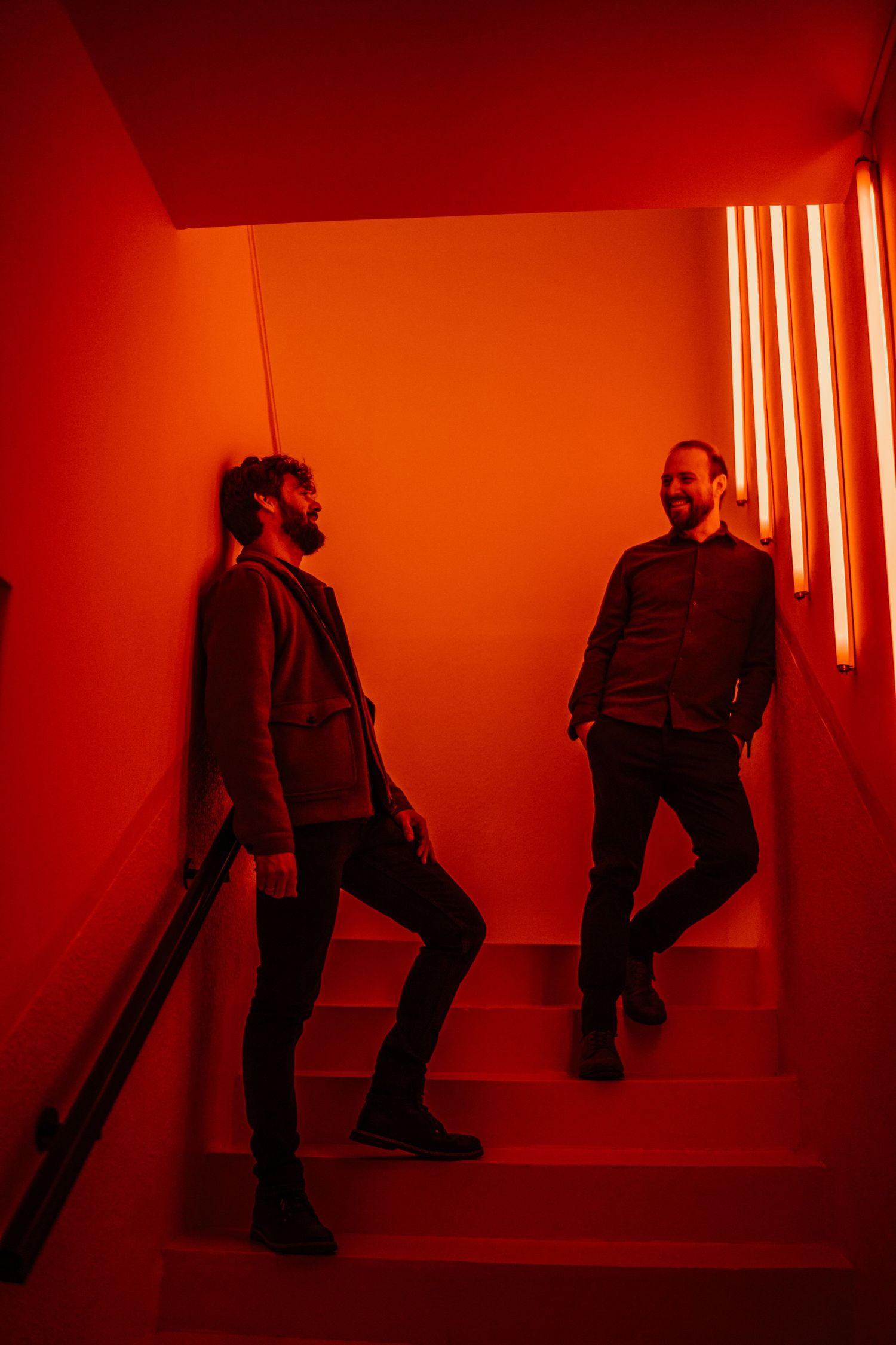 Silhouetted figures in dramatic red lighting create an artistic sequence of movement against a minimalist background.