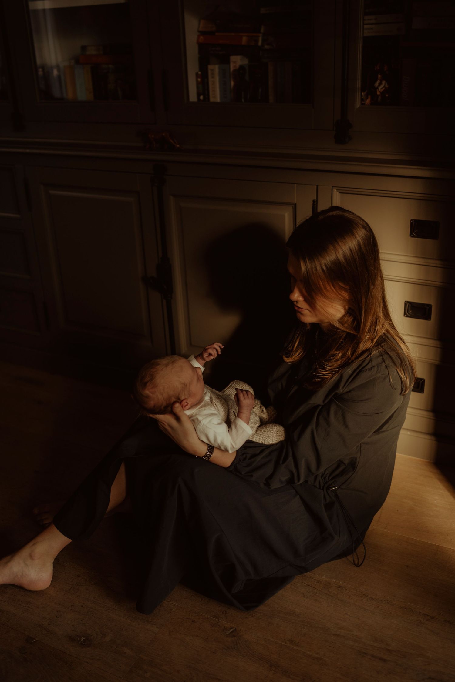 A quiet moment on wooden flooring illuminated by soft ambient light.