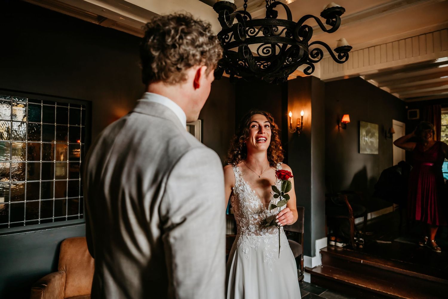 A romantic first dance between newlyweds in an elegantly lit ballroom with ornate chandeliers.