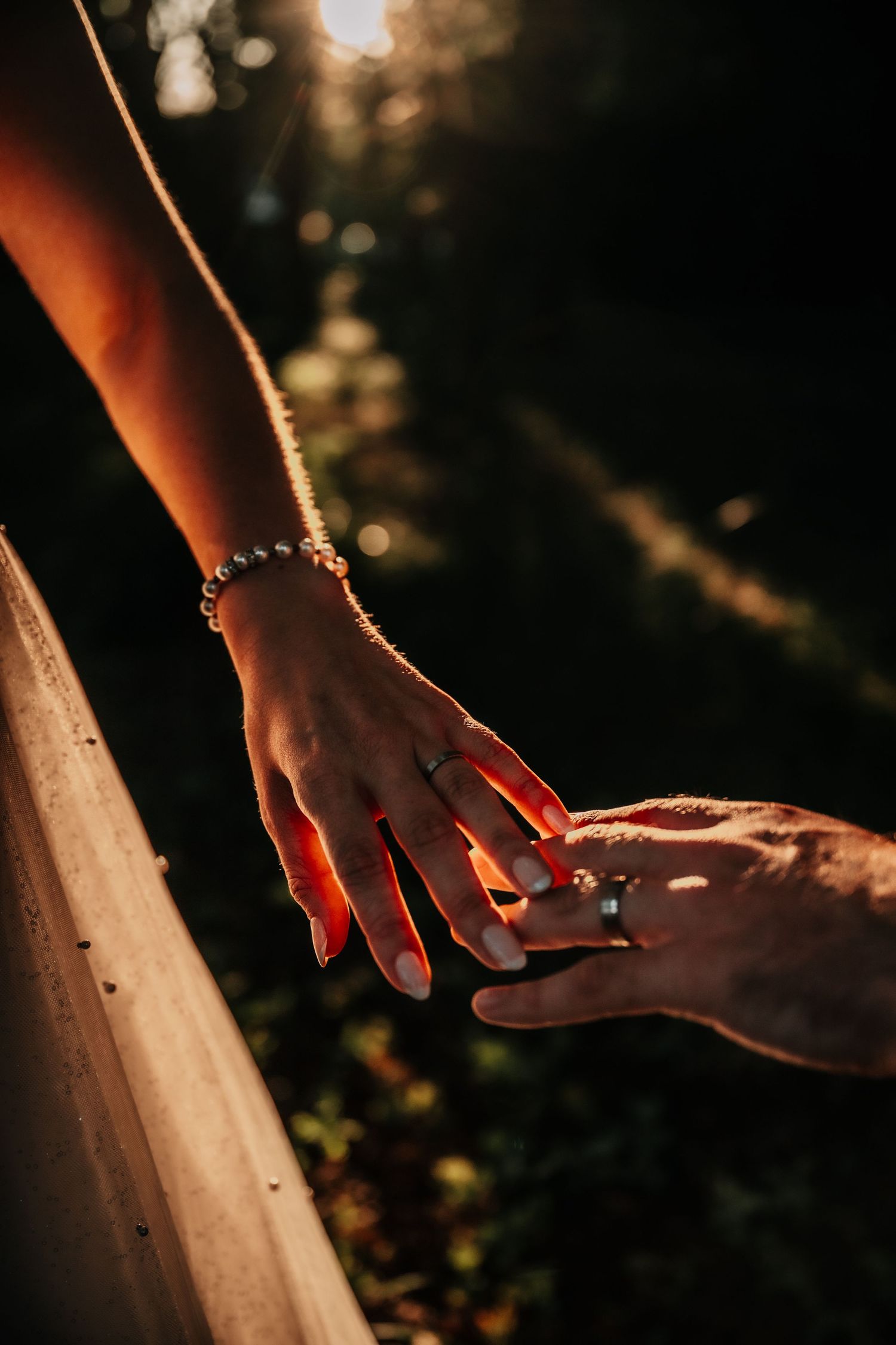 Close-up of hands in warm sunset lighting creating dramatic shadows.