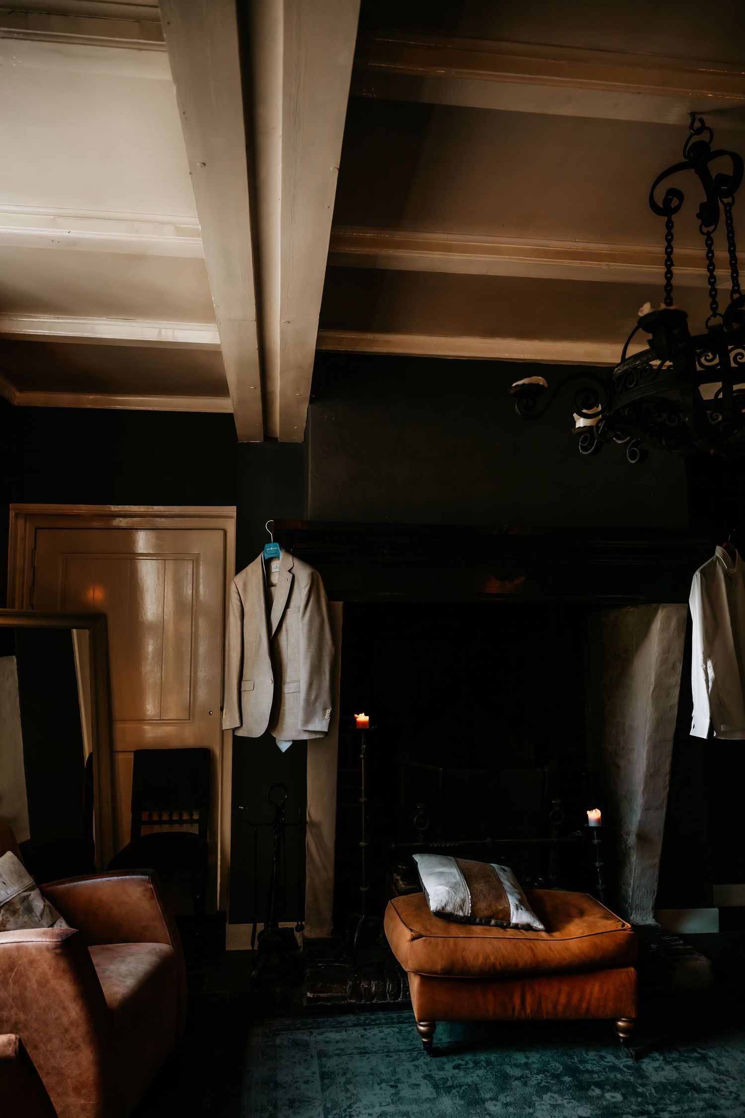 Moody interior shots of a dimly lit room with leather furniture and formal attire displayed.