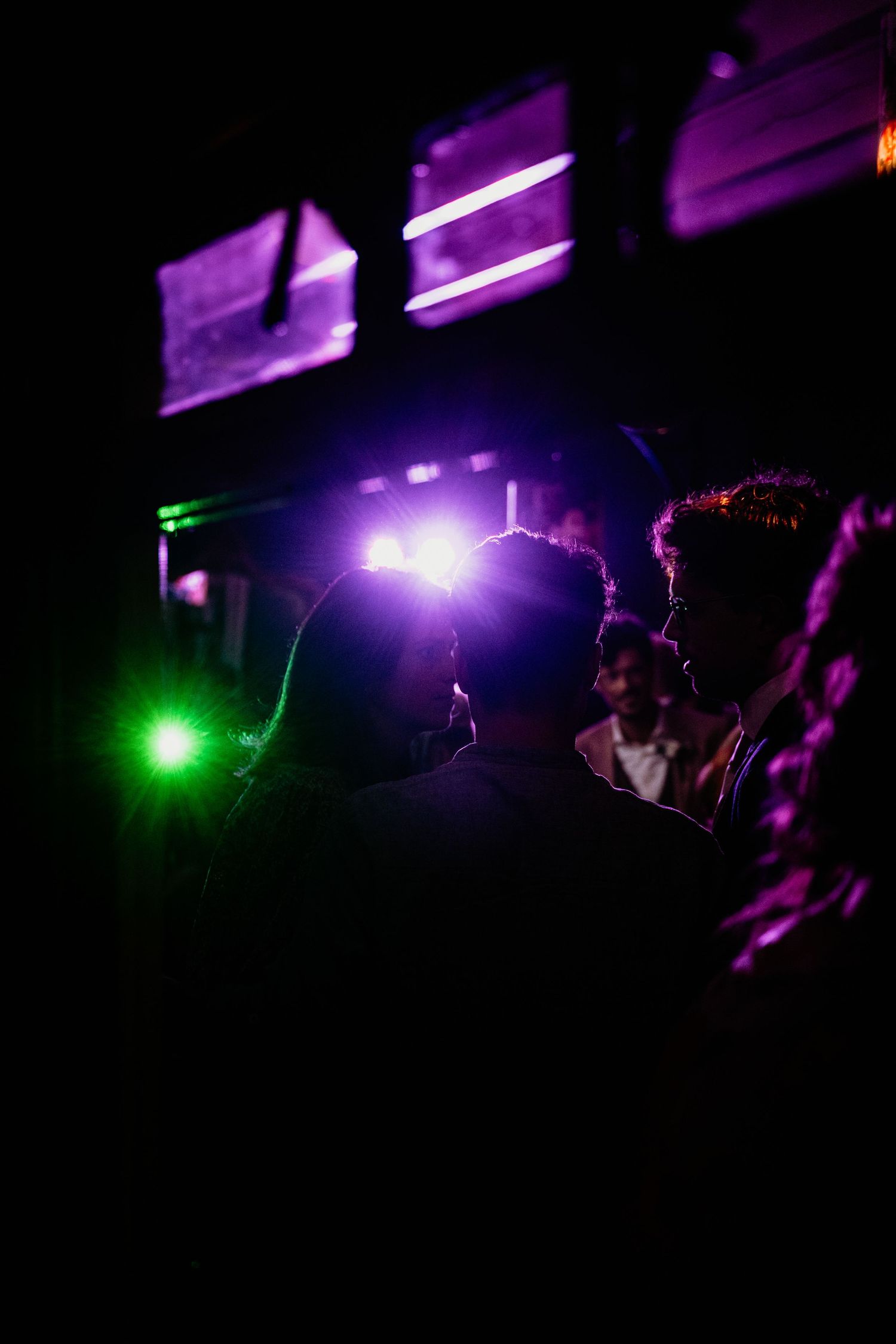 Dance floor illuminated with purple and green lights creating a nightclub atmosphere.