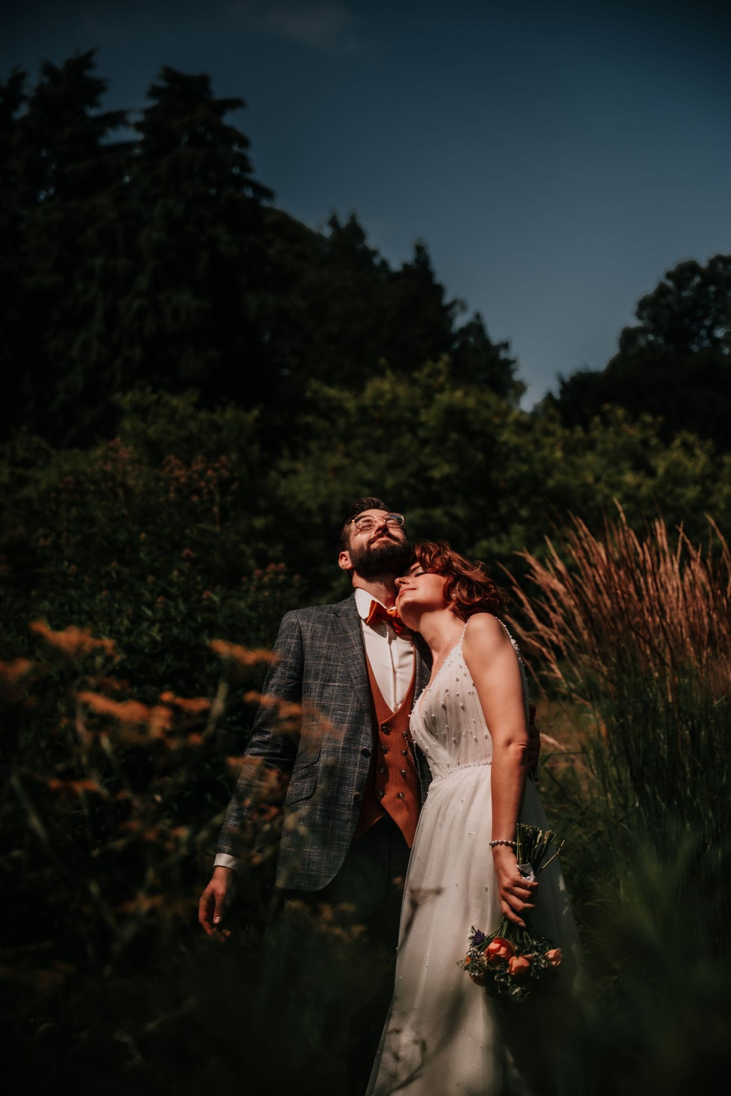 A romantic outdoor photo session among tall ornamental grasses at dusk.