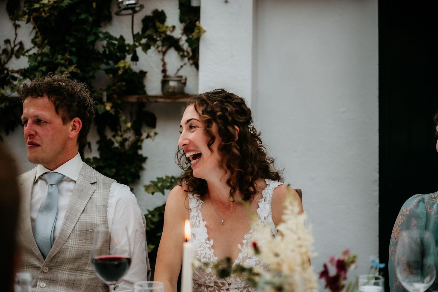 An intimate wedding reception dinner scene with guests enjoying wine and conversation.