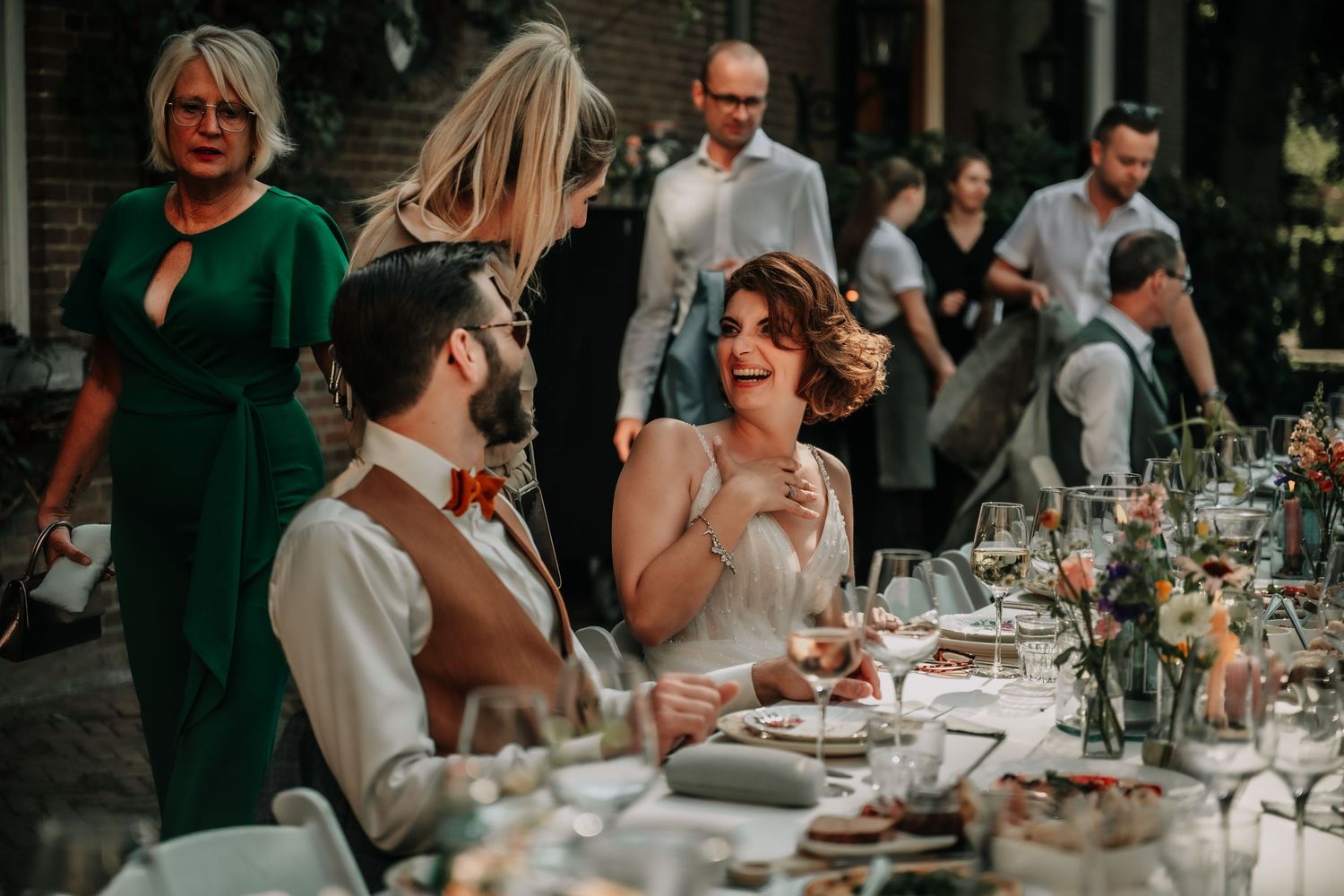 Elegant wedding reception with guests seated at decorated tables.