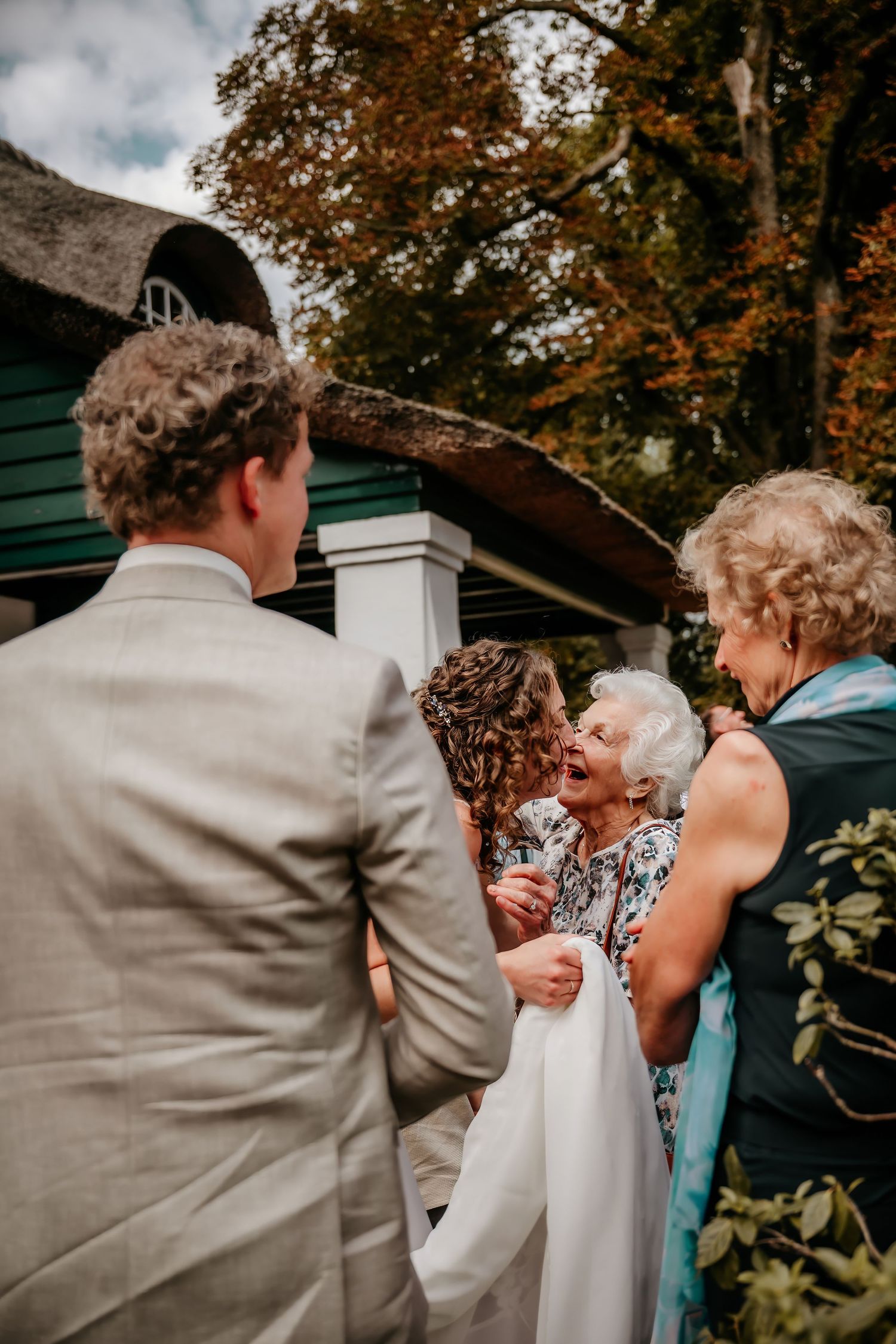 Wedding celebration outdoors with guests in formal attire.