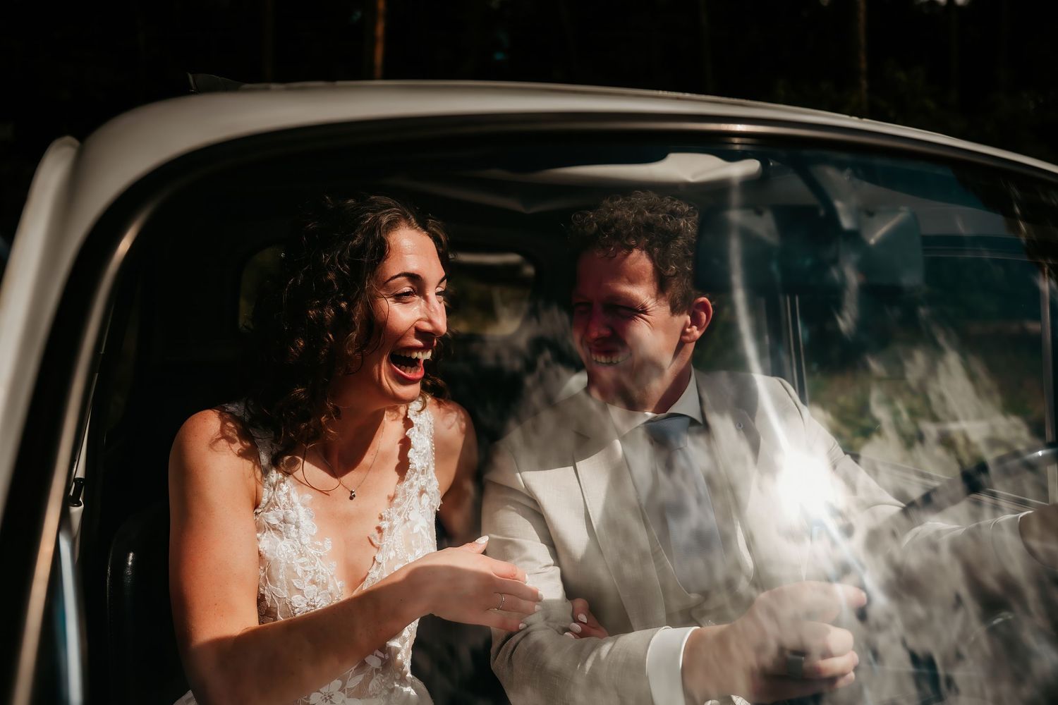 Joyful moment captured inside a car with smoke or fog creating a dreamy atmosphere.