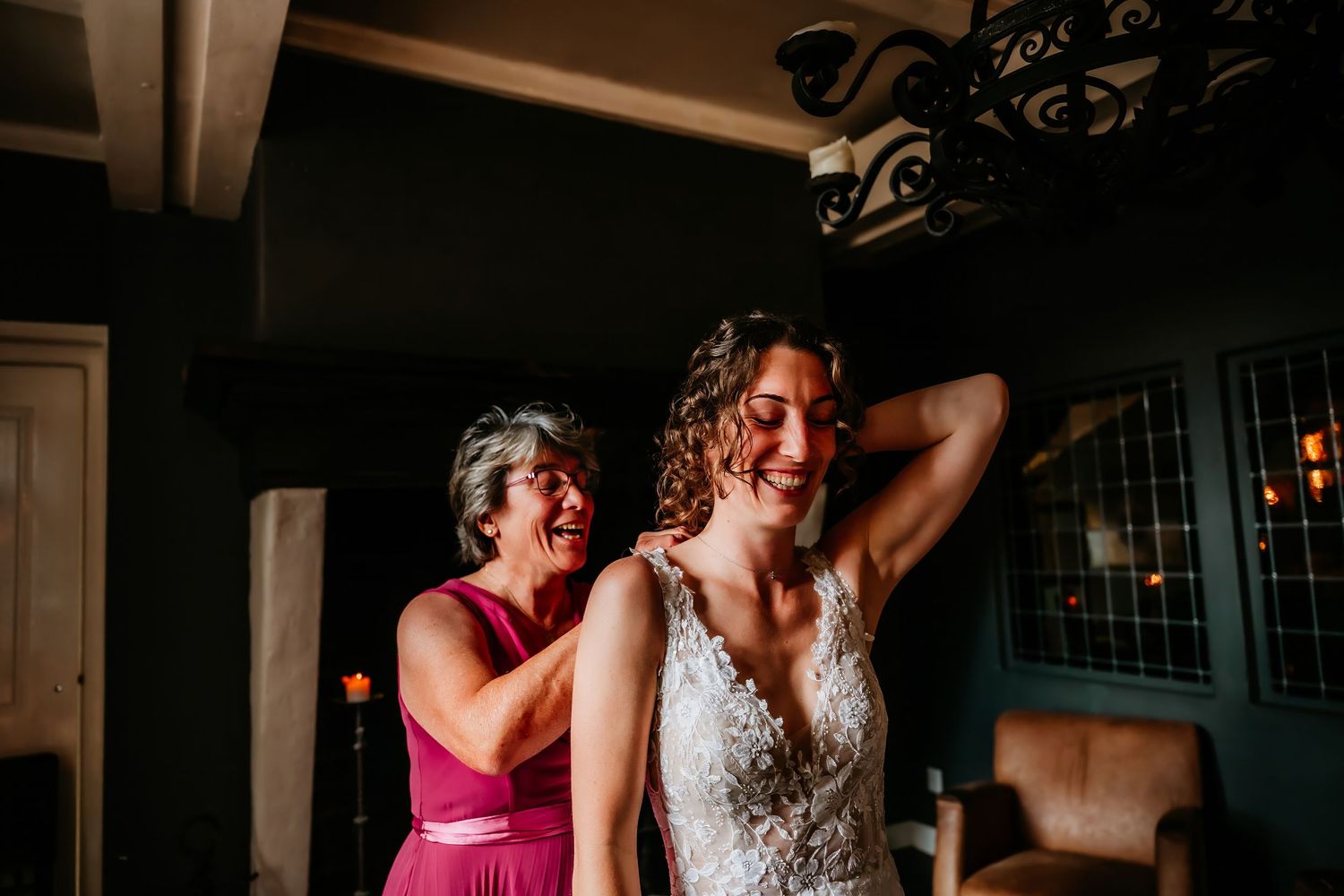 Wedding party members dance and celebrate joyfully on the dance floor at an indoor reception.