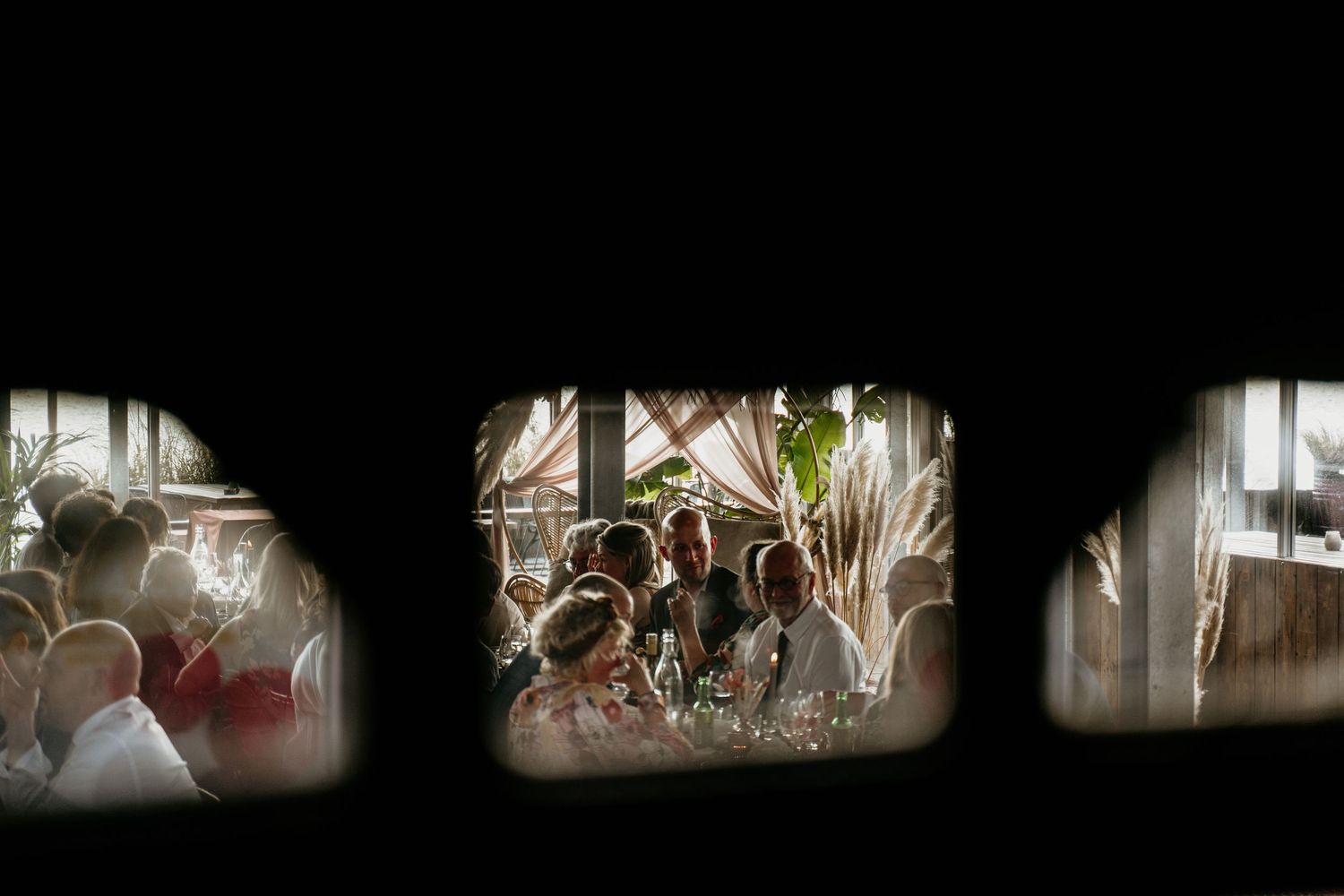 Atmospheric window view of a dimly lit indoor event space.