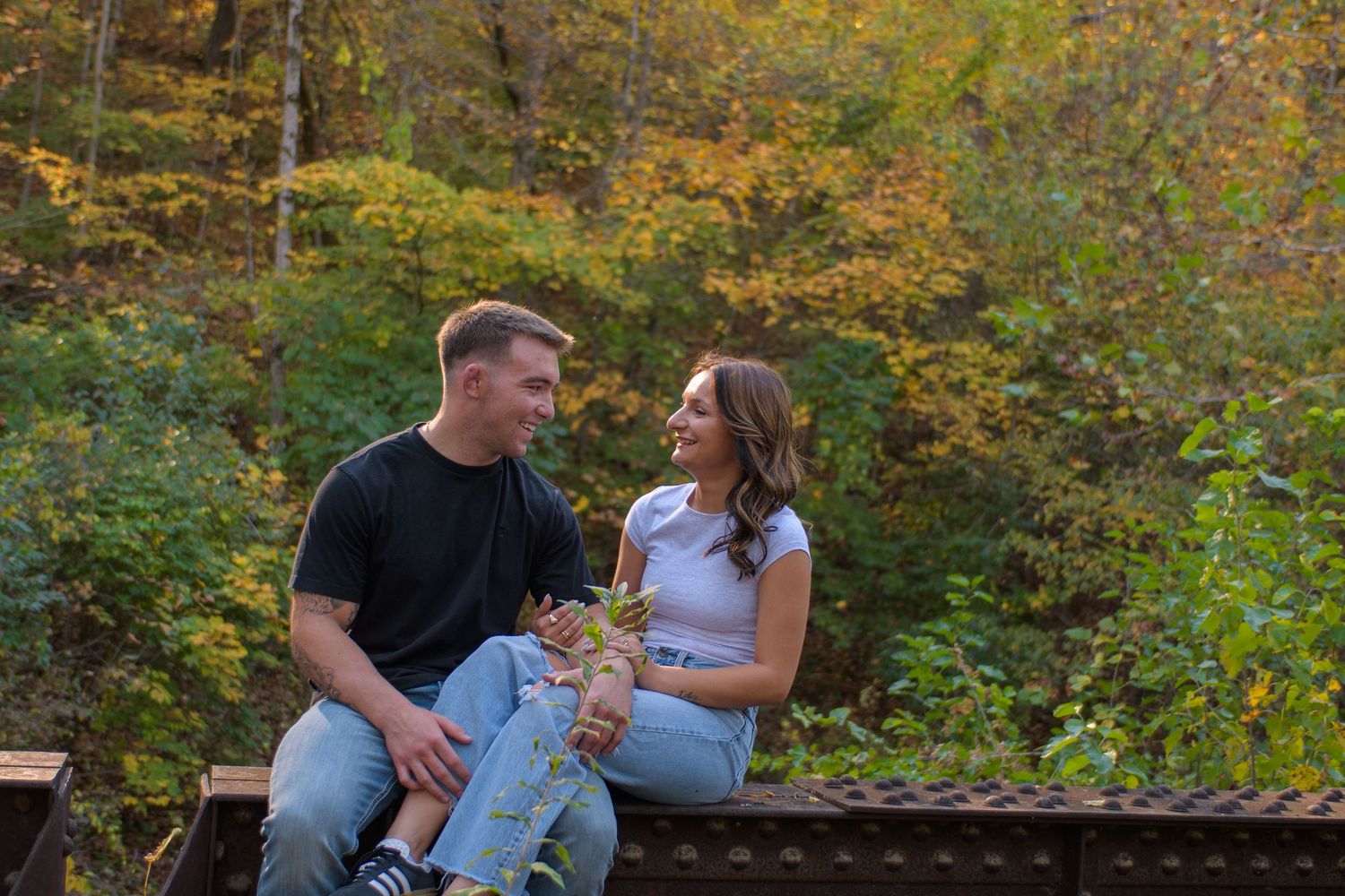 Family enjoying a tender moment together outdoors during an autumn photoshoot in a wooded setting.