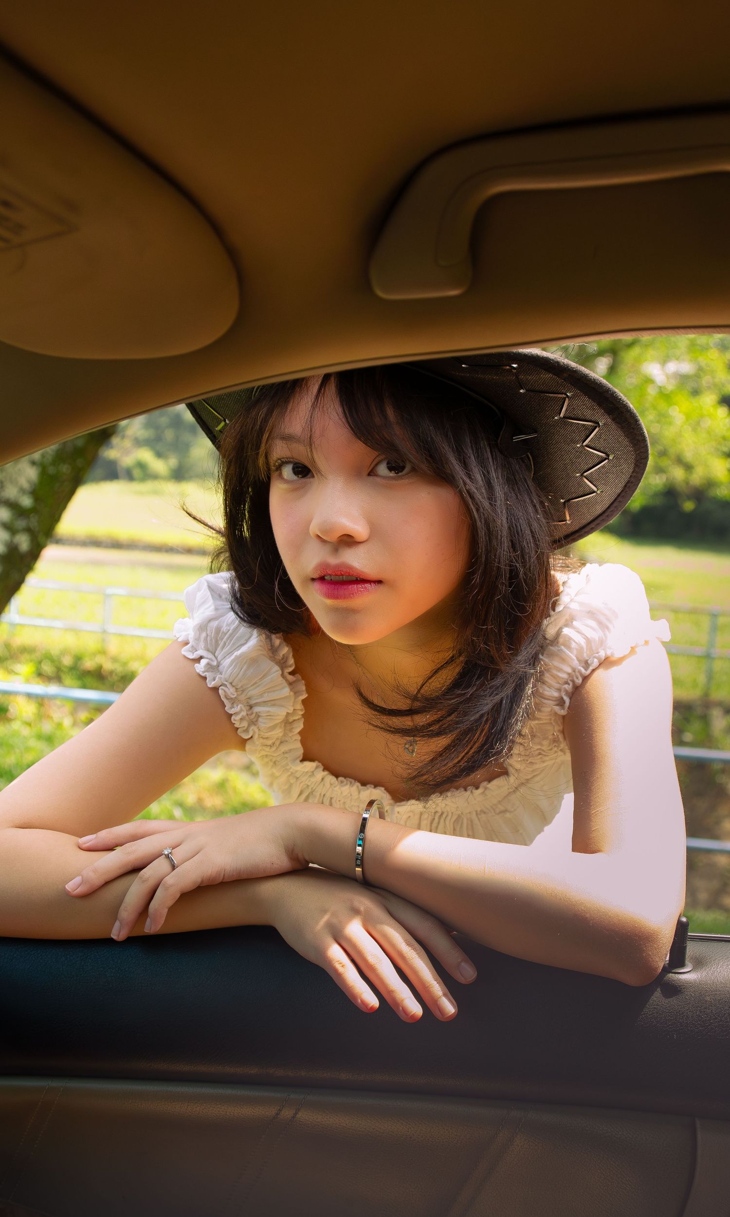 cowgirl leaning into a car